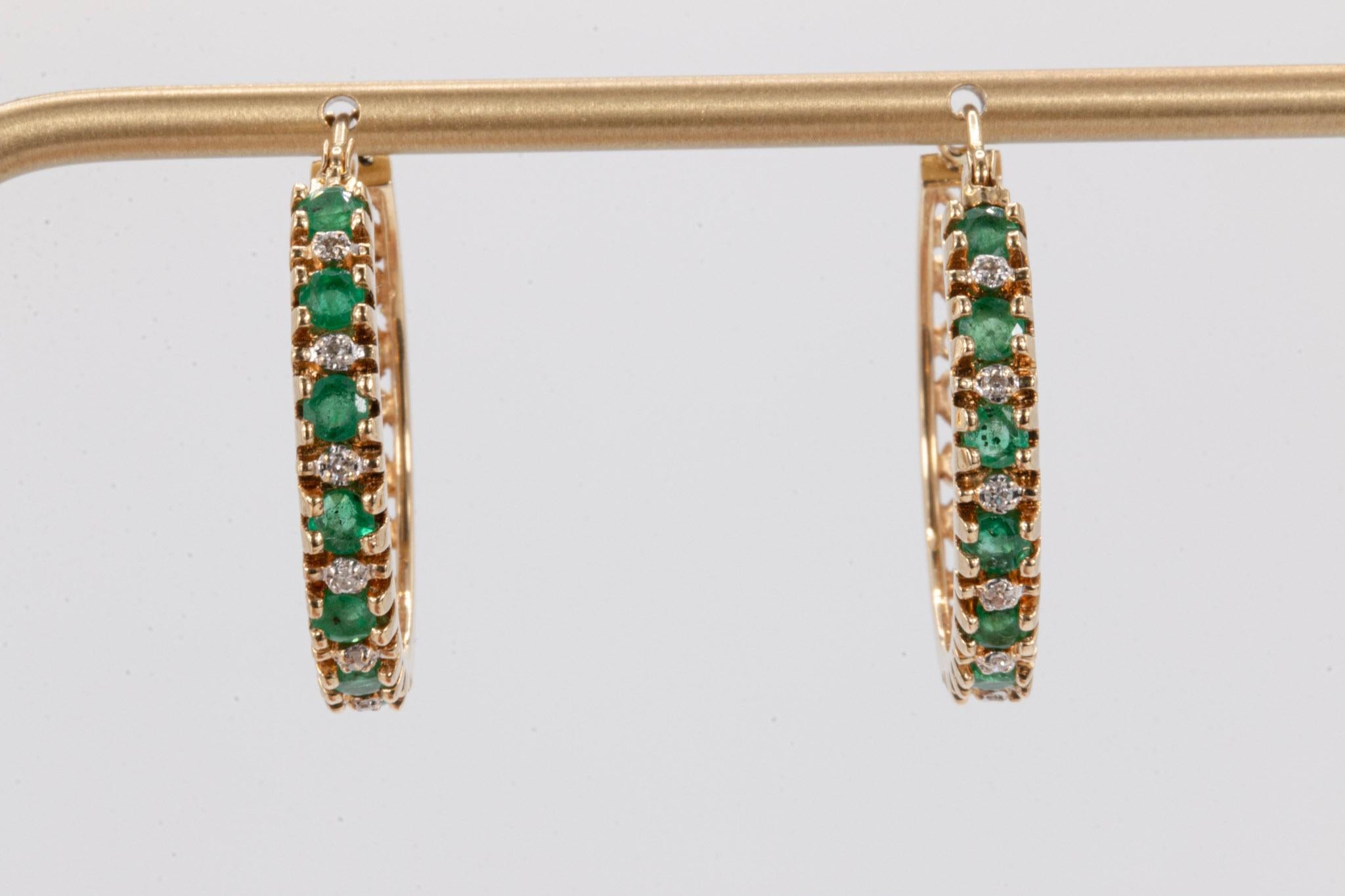 Vintage 14k Gelbgold Hoop Smaragd und runde Diamanten Ohrringe

Diese lebendigen und zeitlosen Vintage-Ohrringe zeigen die satte grüne Schönheit von sieben brasilianischen Smaragden, von denen jeder fein gefasst ist, um das Licht einzufangen und