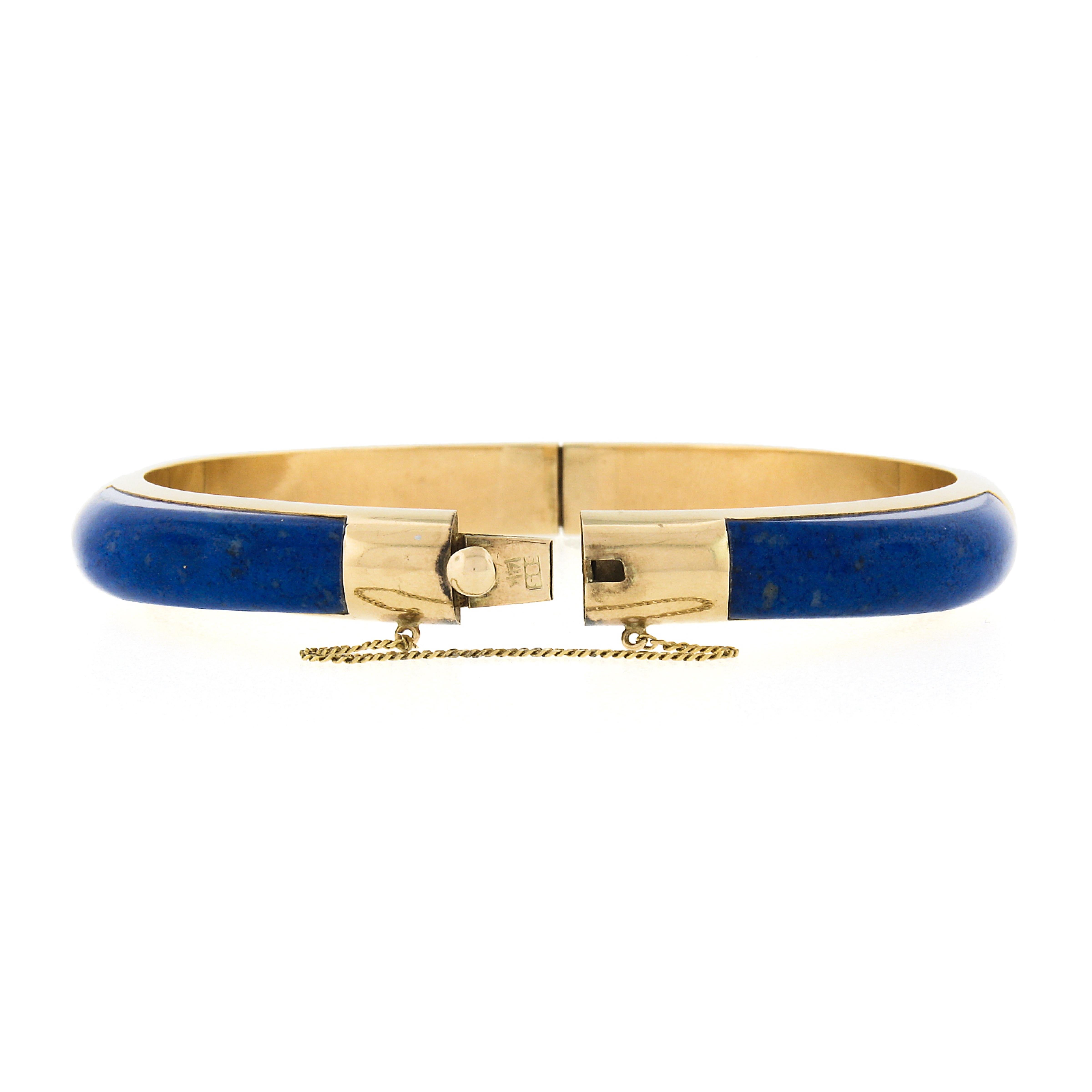 This beautiful vintage bangle bracelet is very well crafted in solid 14k yellow gold and features fine quality natural lapis stones neatly stationed and inlaid set throughout. The 4 custom cabochon cut stones have a gorgeous brilliant blue color
