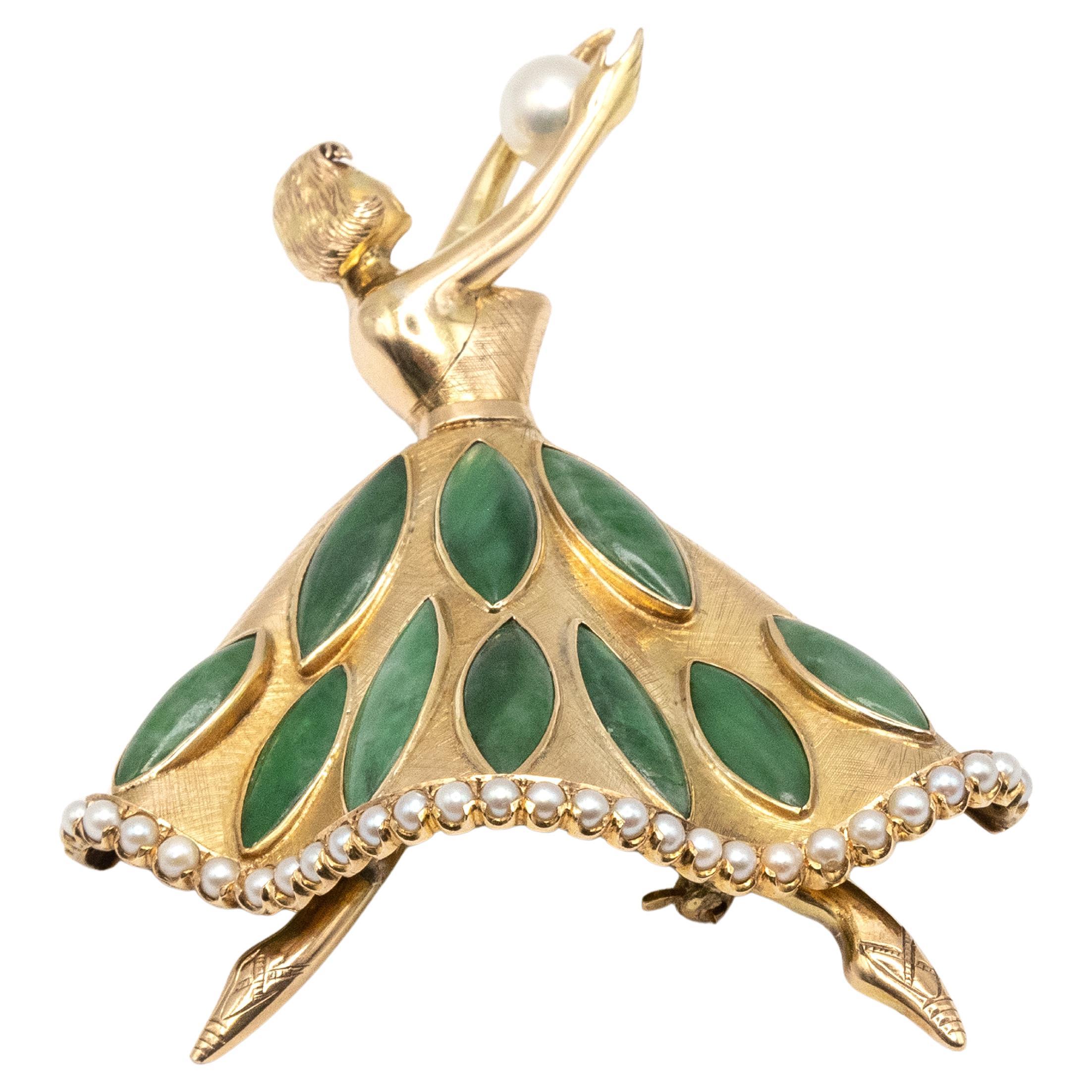Un encantador y elegante broche de bailarina de mediados de siglo elaborado en oro amarillo de 14 quilates. La estilizada bailarina está representada en una pose dinámica, sosteniendo en alto una única perla cultivada. Su voluminosa falda lleva