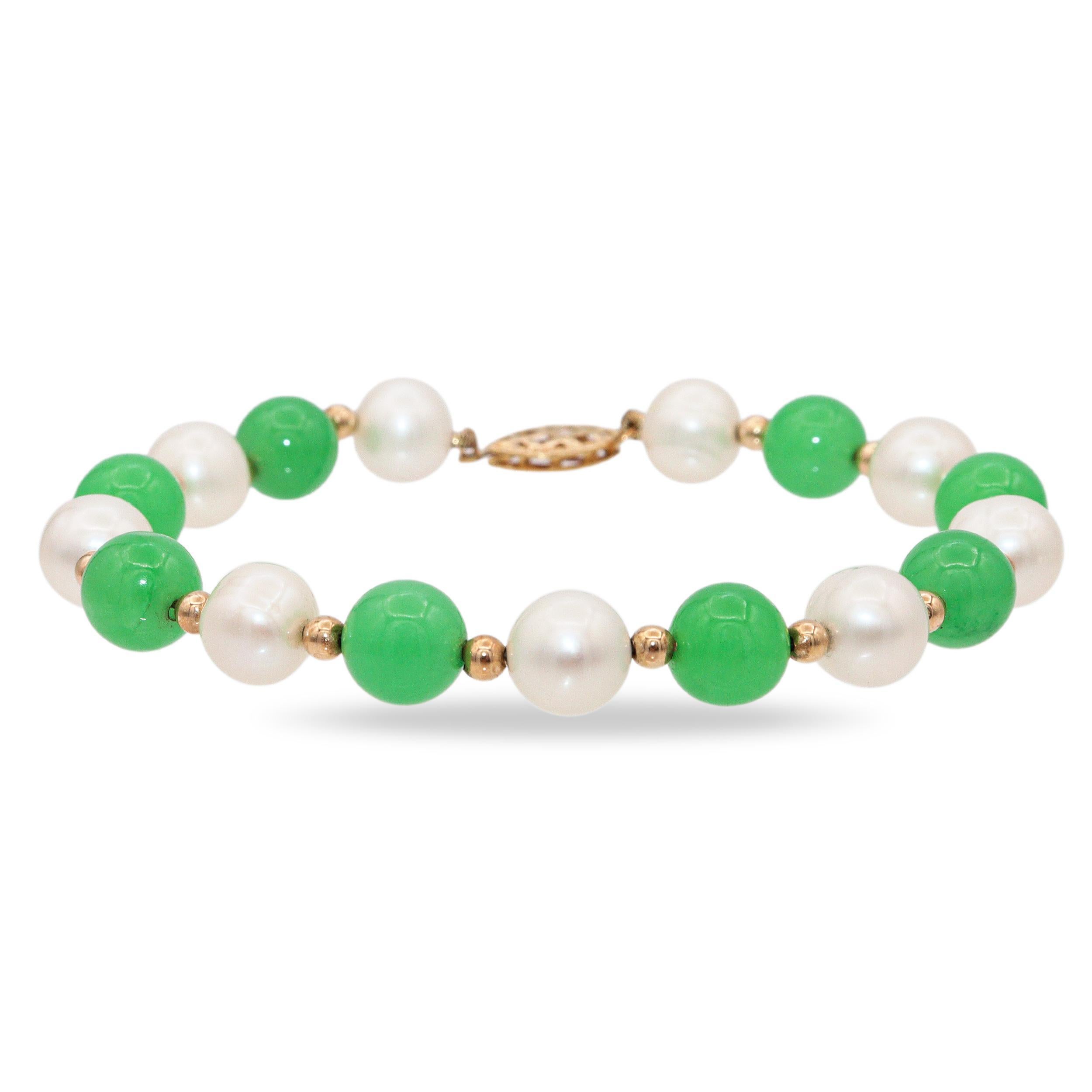 Questo elegante bracciale vintage combina la bellezza senza tempo delle perle con il fascino vibrante della giada. Il design alterna perle bianche e perle di giada verde, separate da delicati distanziatori in oro giallo 14k che ne esaltano