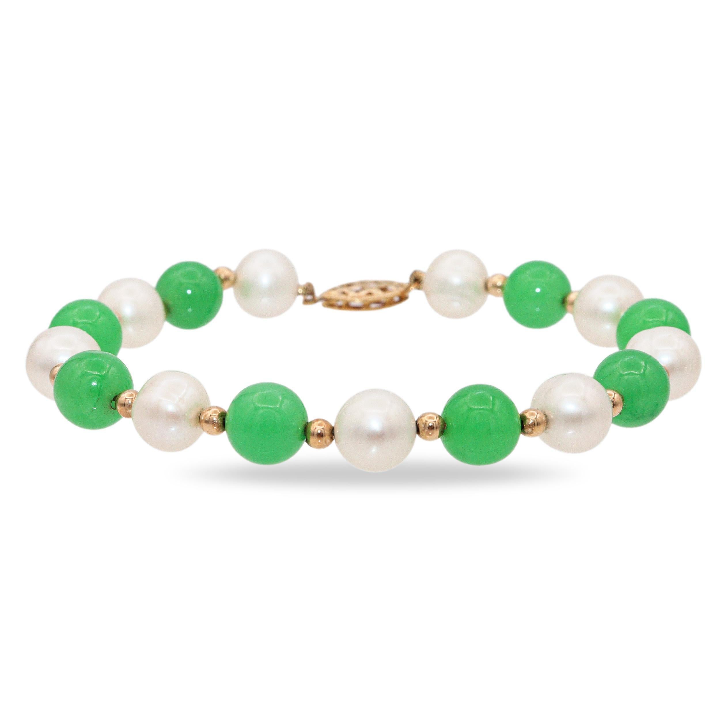 Questo elegante bracciale vintage combina la bellezza senza tempo delle perle con il fascino vibrante della giada. Il design alterna perle bianche e perle di giada verde, separate da delicati distanziatori in oro giallo 14k che ne esaltano