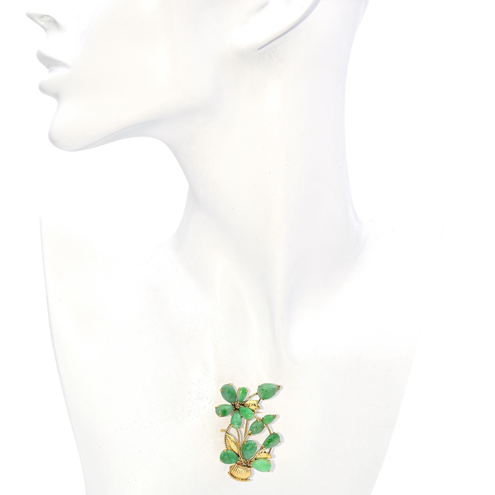 This brooch, crafted in 14K yellow gold, features delicate jade flowers in soft green tones, elegantly arranged in a beautifully detailed gold basket. The intricate design blends warmth and elegance in a timeless, nature-inspired piece.

Weight: 8.4