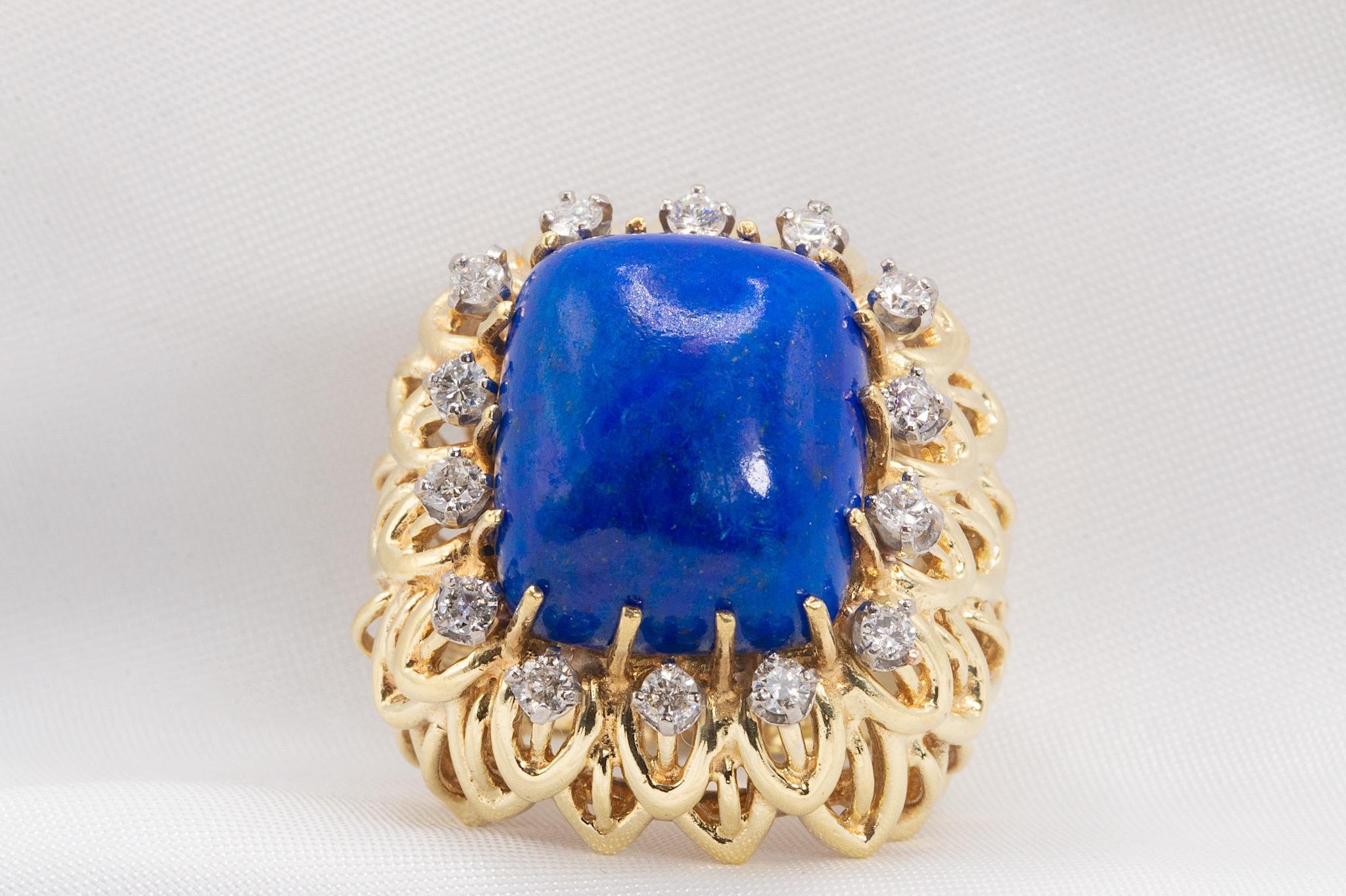 This exquisite vintage ring is crafted in 14K yellow gold, featuring a striking cabochon-cut 16.5 x 13.5mm lapis lazuli centerpiece. The rich blue stone is elegantly framed by round brilliant-cut diamonds with an estimated total weight of 0.70