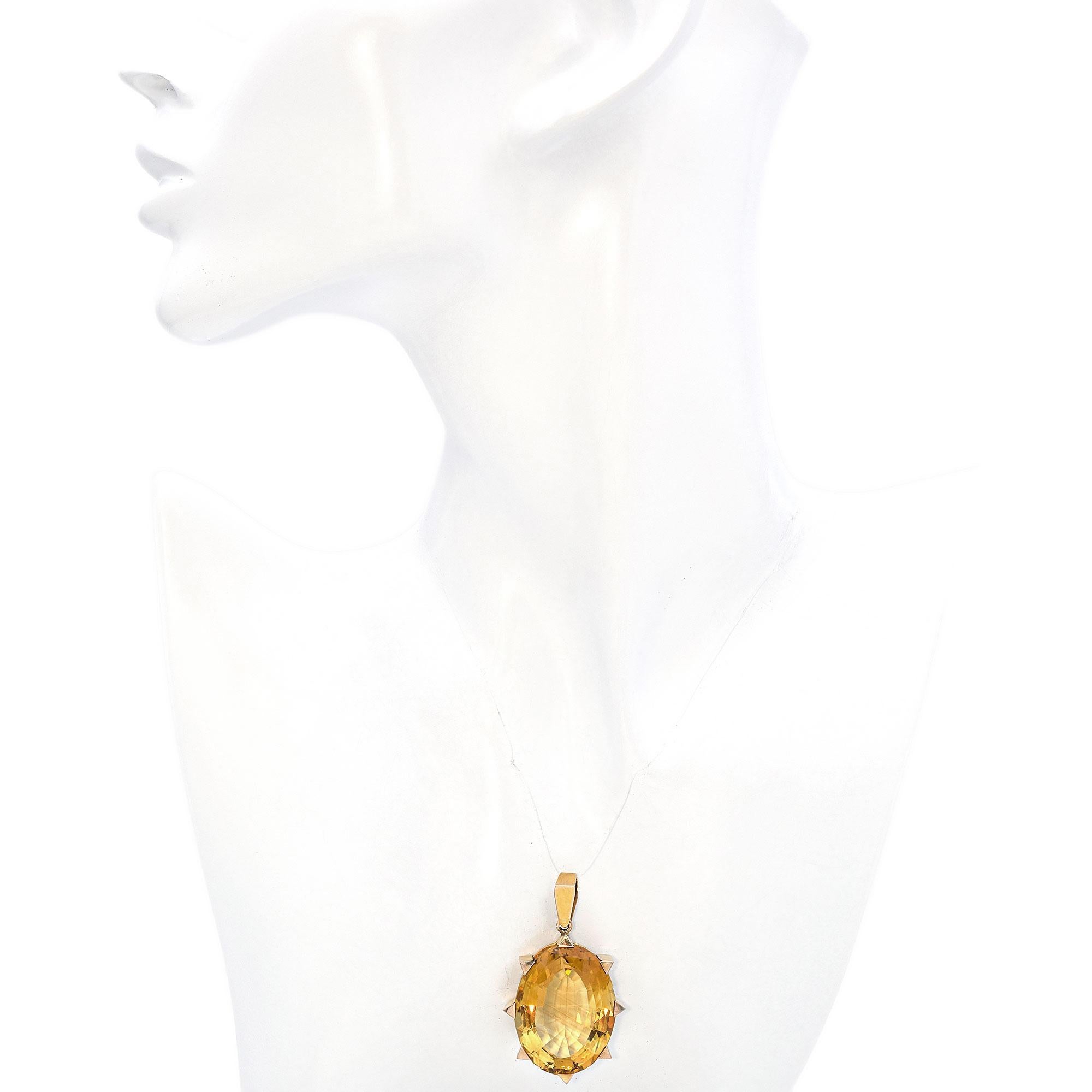 Elegant pendentif vintage en or jaune 14K avec citrine. Ce pendentif saisissant présente une grande citrine ovale facettée, sertie dans une monture en or jaune 14 carats. La pierre précieuse est fixée par des griffes en or bien visibles qui ajoutent