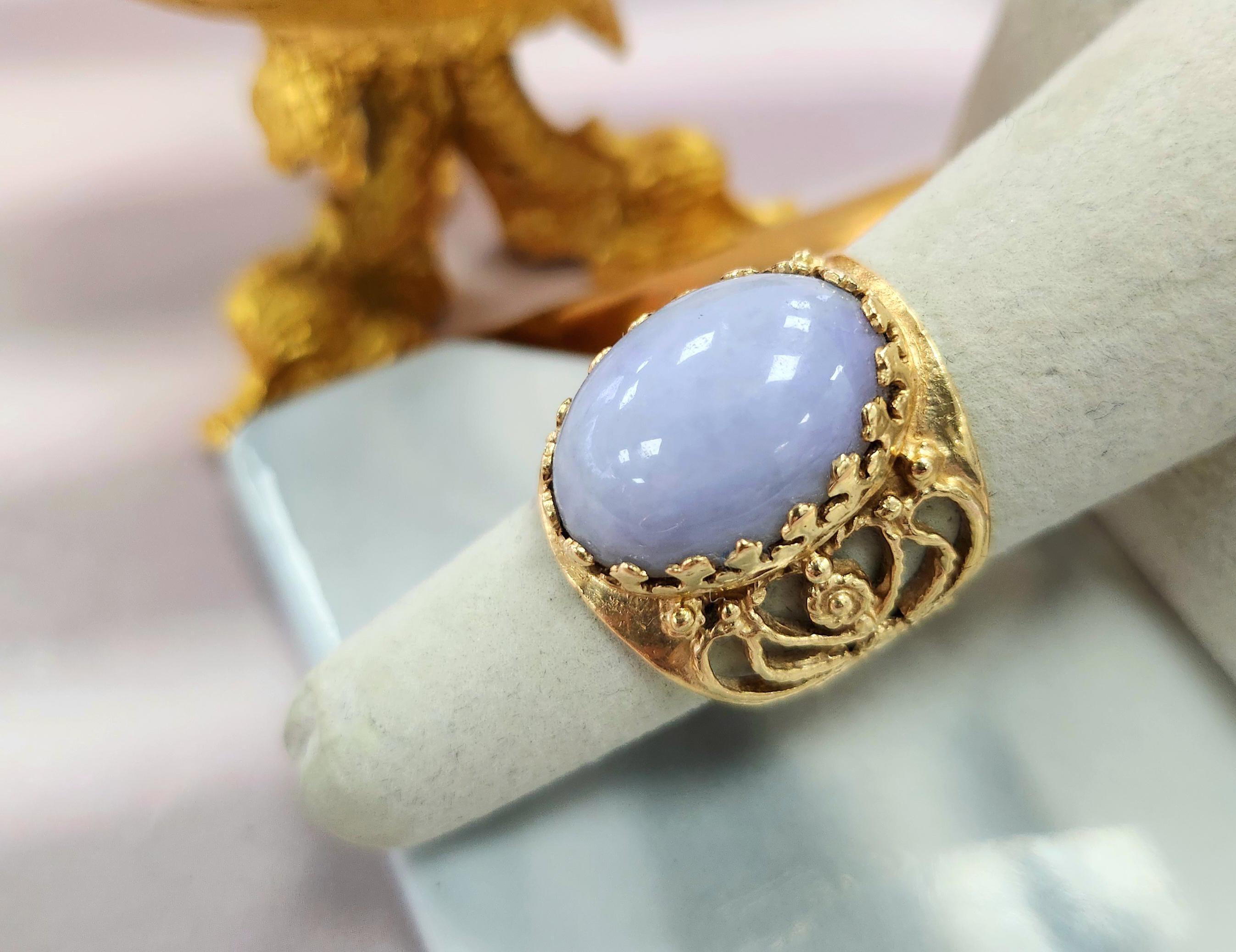 This is a vintage ring, featuring a beautiful pastel lavender jade oval. 
The jade is securely crown-prong set in a whimsical band adorned with intricate rope design details.

Details:

Material: Natural lavender jade  (17.5 x 13.5mm) 
Band Width:
