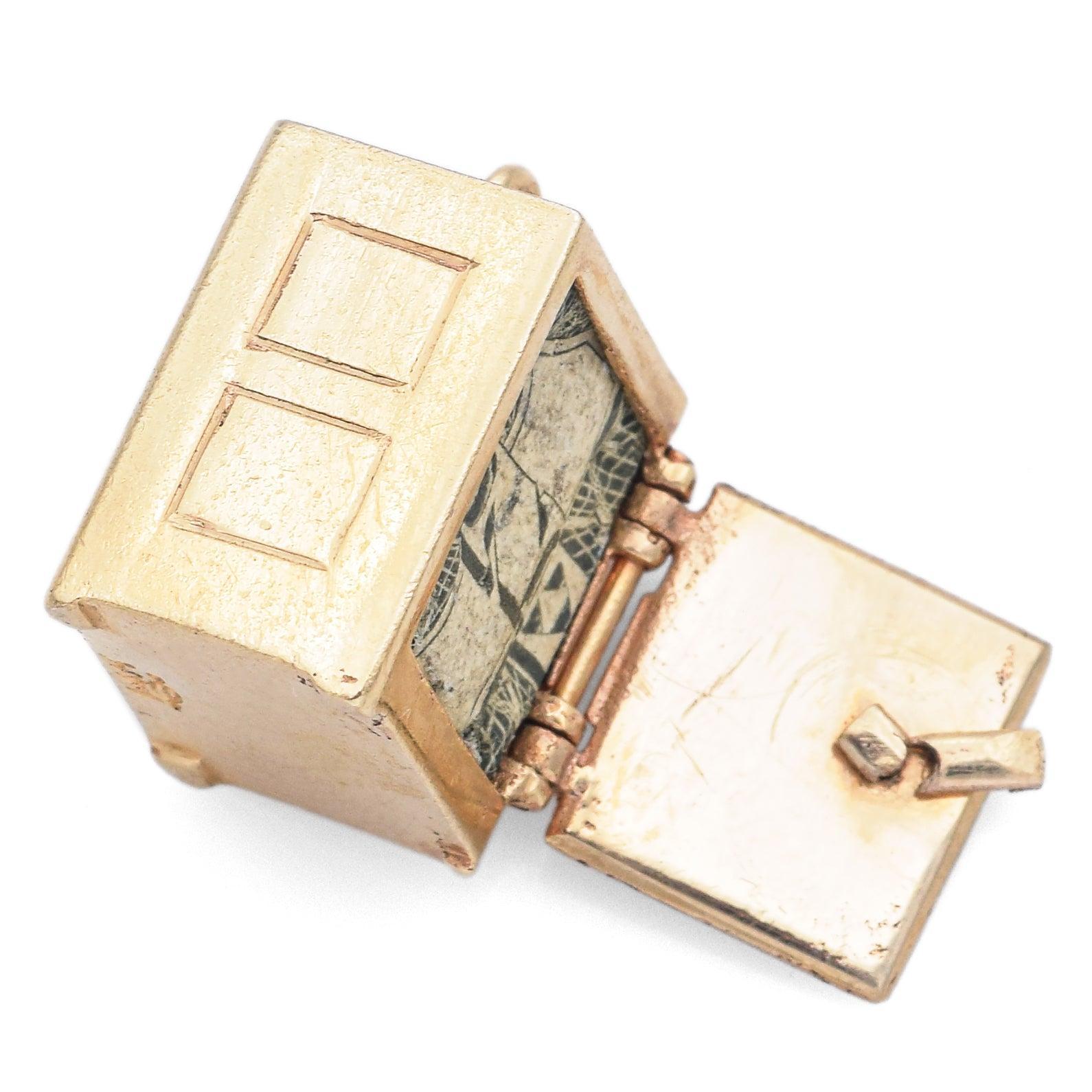 Fantaisiste et finement travaillée, cette breloque vintage en or jaune 14k est conçue comme un coffre-fort miniature doté d'une porte mobile. En l'ouvrant, vous découvrirez une délicieuse surprise : un morceau de billet d'un dollar caché à