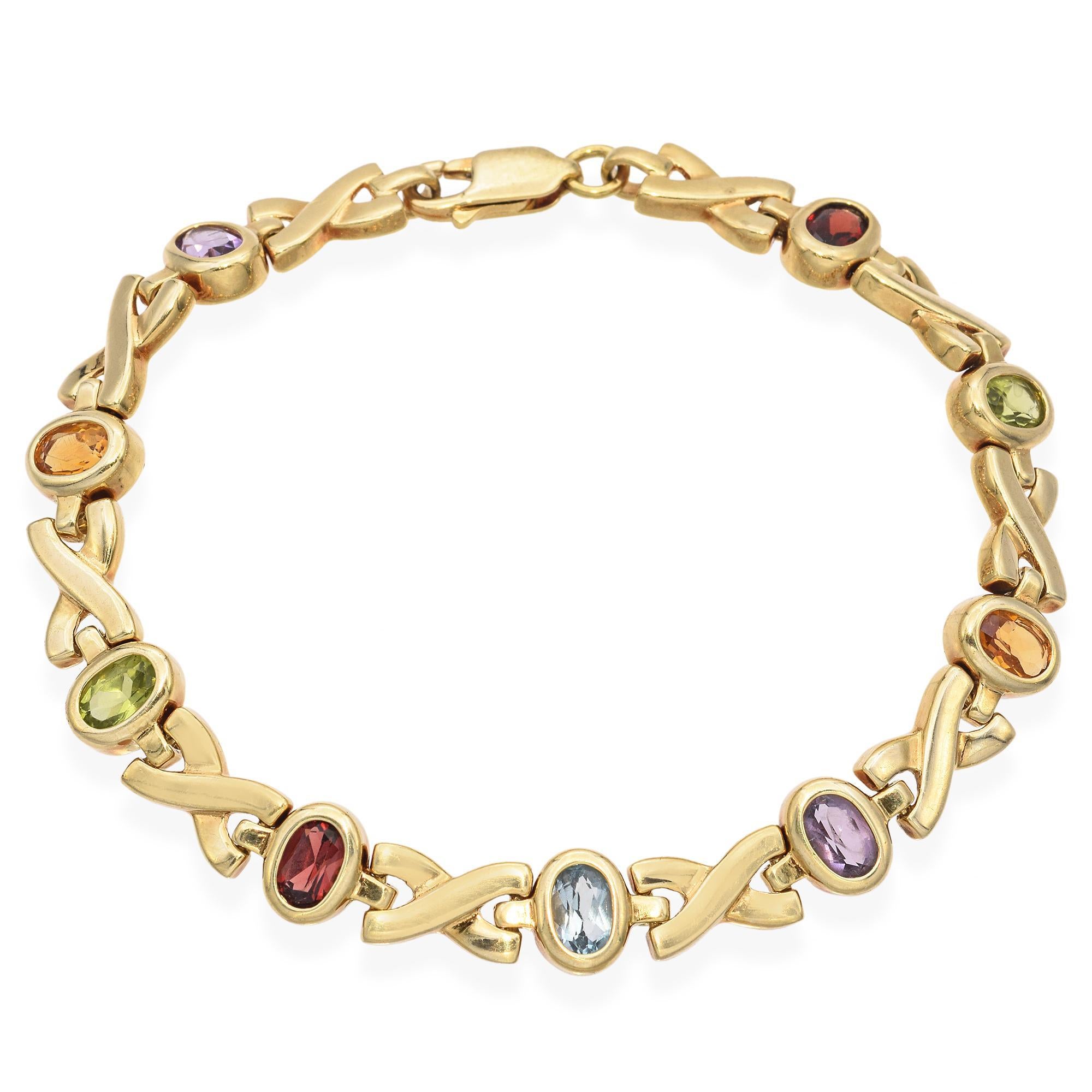 Esta pulsera vintage de oro amarillo de 14 quilates presenta un alegre conjunto de piedras preciosas de colores, cada una engastada en un elegante diseño enlazado. La mezcla de piedras añade una personalidad vibrante a la vez que mantiene un aspecto