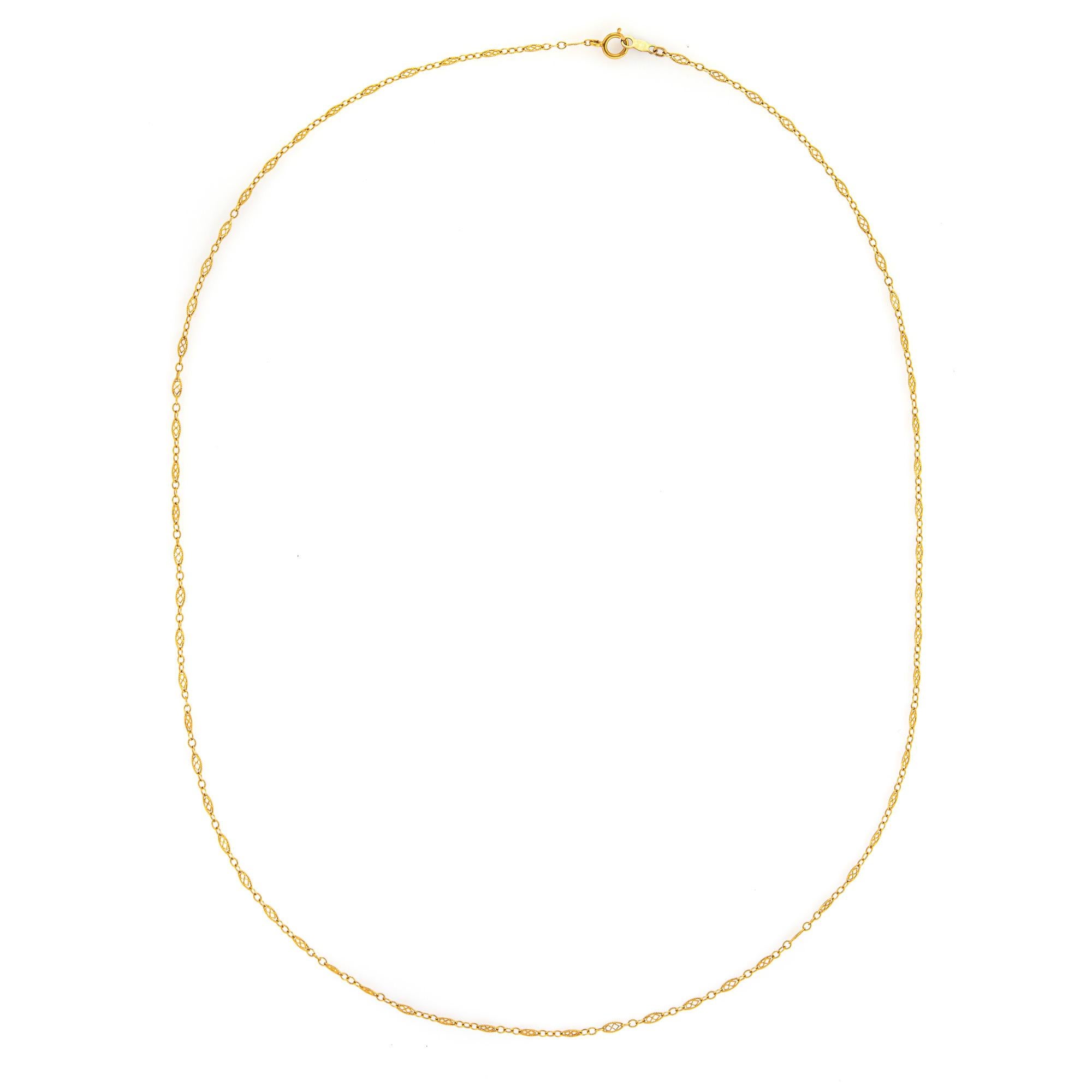 Stylish and finely detailed vintage necklace crafted in 14 karat yellow gold (circa 1940s to 1950s).  

The necklace features oval links with intricate fine detail to the center. The oval links are 2mm wide with the necklace offering a delicate