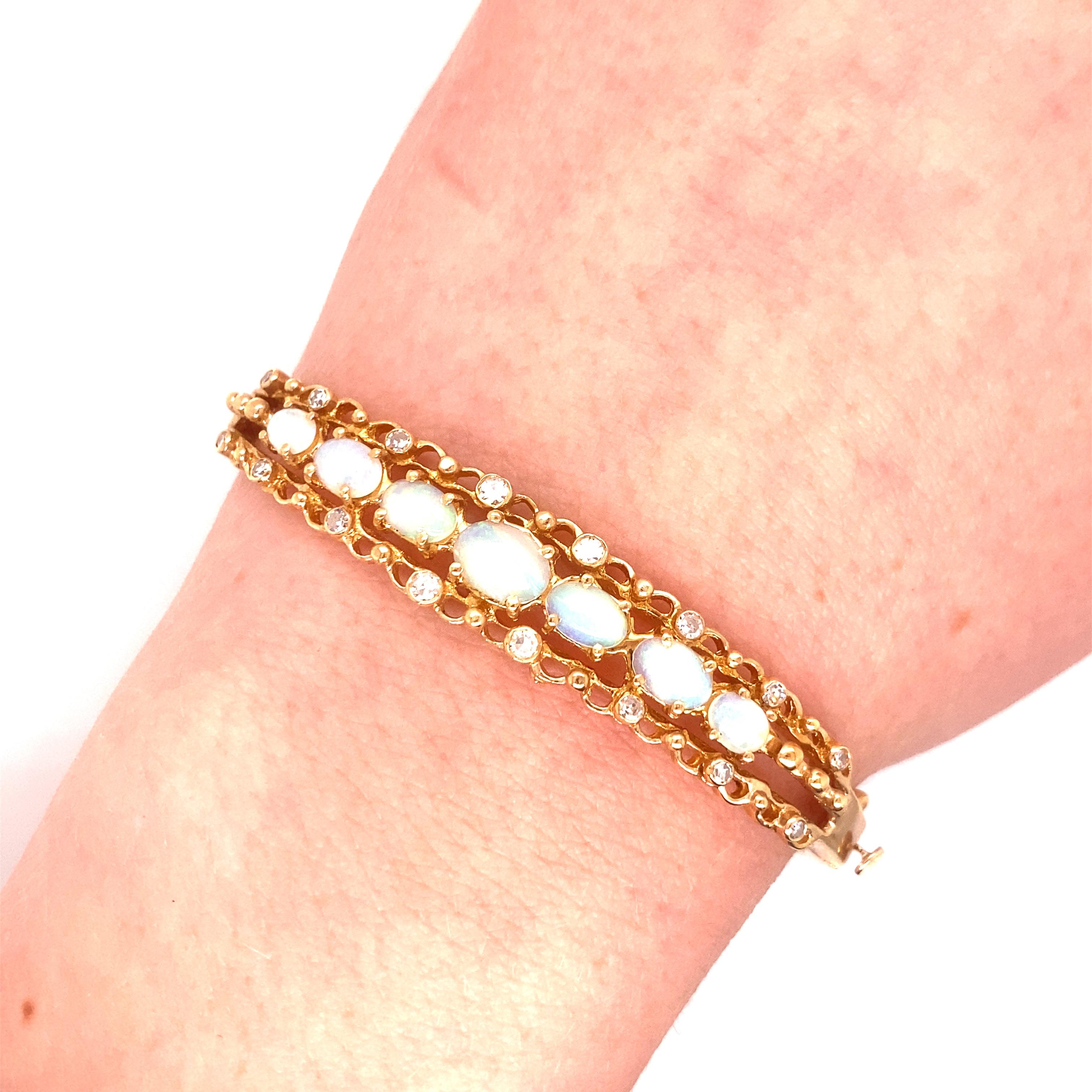 Bracelet vintage en or jaune 14K avec opales et diamants - Le bracelet contient 7 opales ovales graduées avec un jeu de couleurs vertes/bleues. Les tailles vont de 7 x 5mm, 6 x 4mm et 5 x 3mm. Les 16 diamants taillés en une seule pièce et sertis