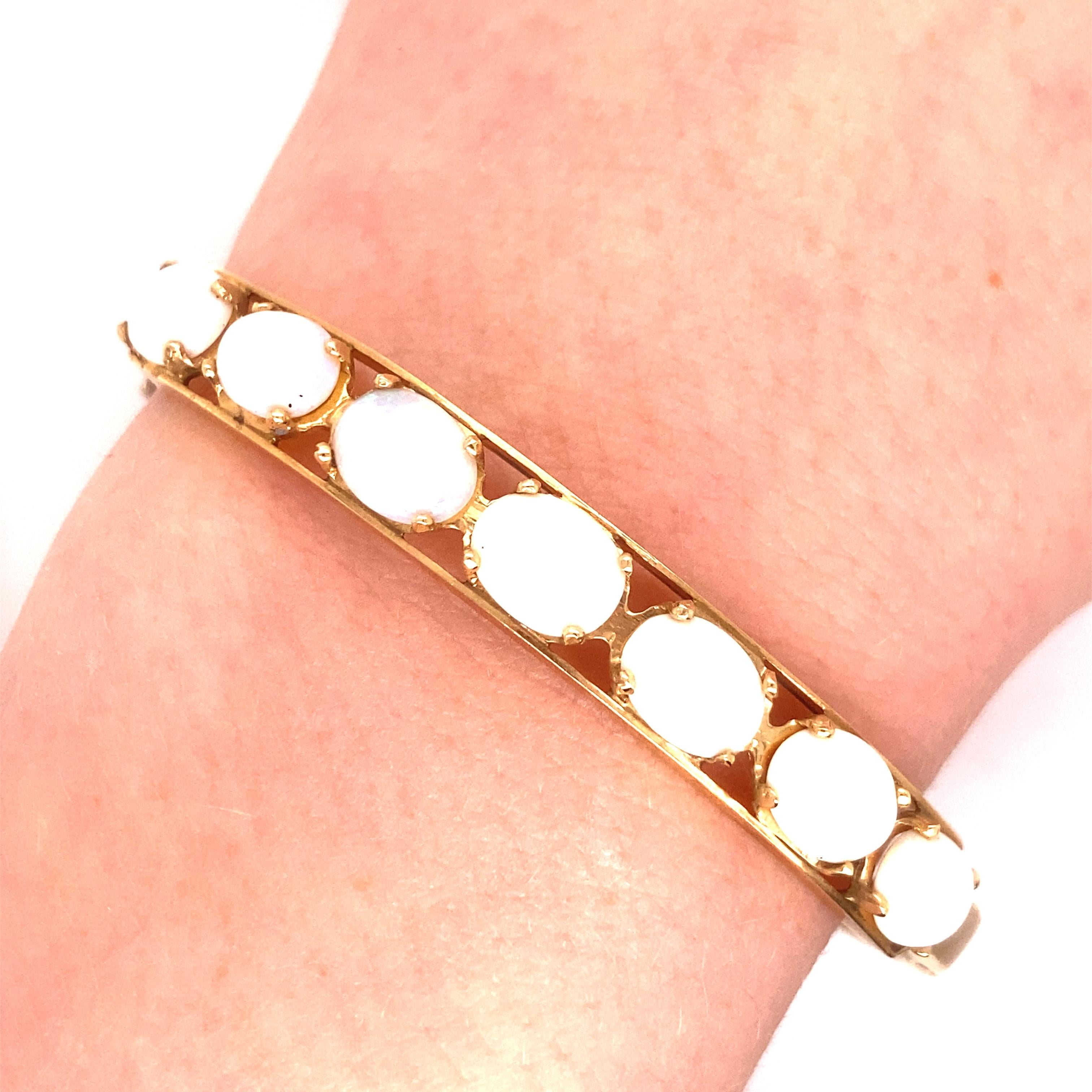 Bracelet opale vintage en or jaune 14k - Le bracelet contient 7 opales ovales qui mesurent environ 8 x 6 mm. Ils sont de couleur blanche avec des jeux de couleur verte et rouge. Le bracelet fait 25 pouce de large. Le diamètre intérieur est de 2