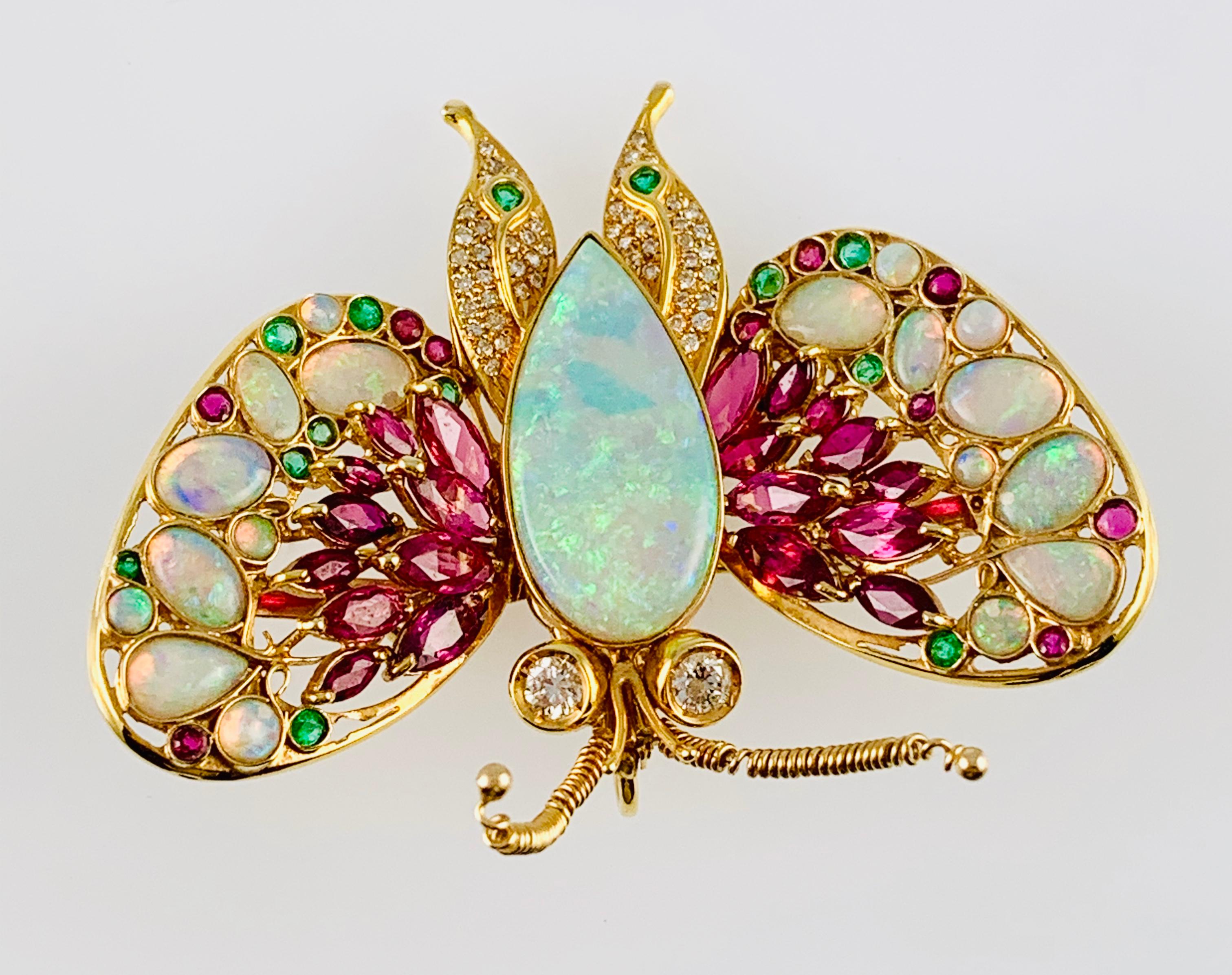 Absolutely Stunning Vintage Butterfly Brooch! Made in 14K yellow Gold and it dominated by a very Large and Colorful Pear Shaped Opal Body and wings that are accented by Diamonds, Rubies and Emeralds! The Butterfly has two bezel set diamonds for