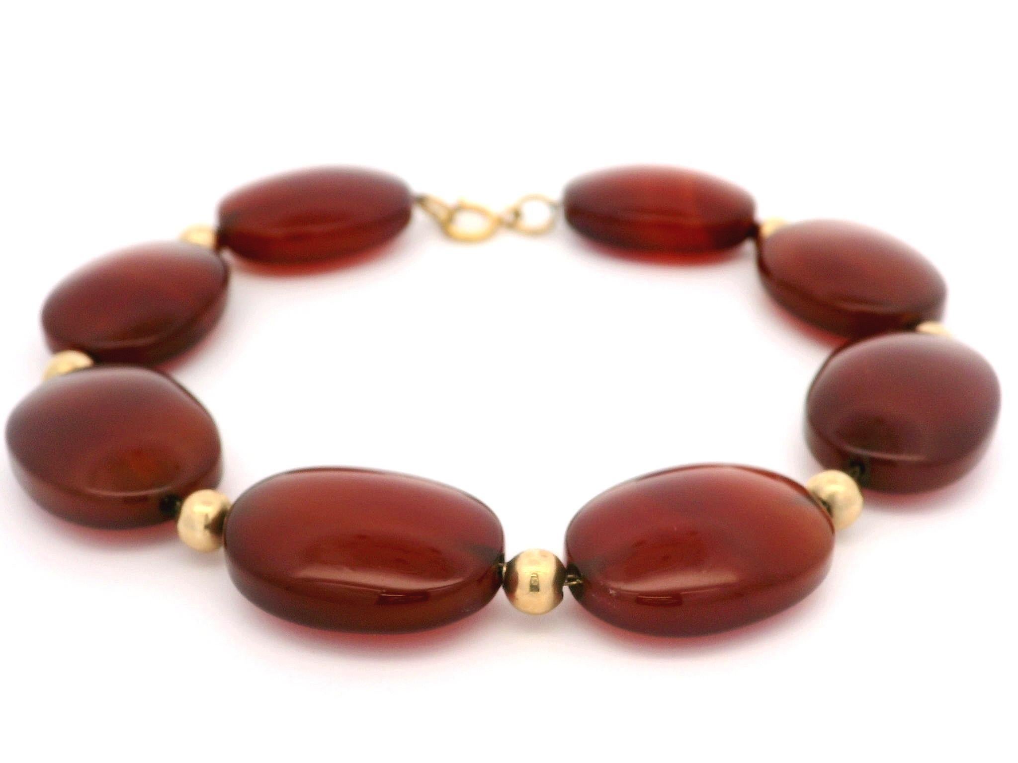 --Stone(s):--
(8) Natural Genuine Carnelian - Oval Shape - Wire Set -  Deep Dark Red-Brown Color - 19.8x14.7mm each (approx.)

Material: 14K Solid Yellow Gold Clasp & Beads
Weight: 26.06 Grams
Chain Type: Carnelian & Gold Bead Links on Cable Link