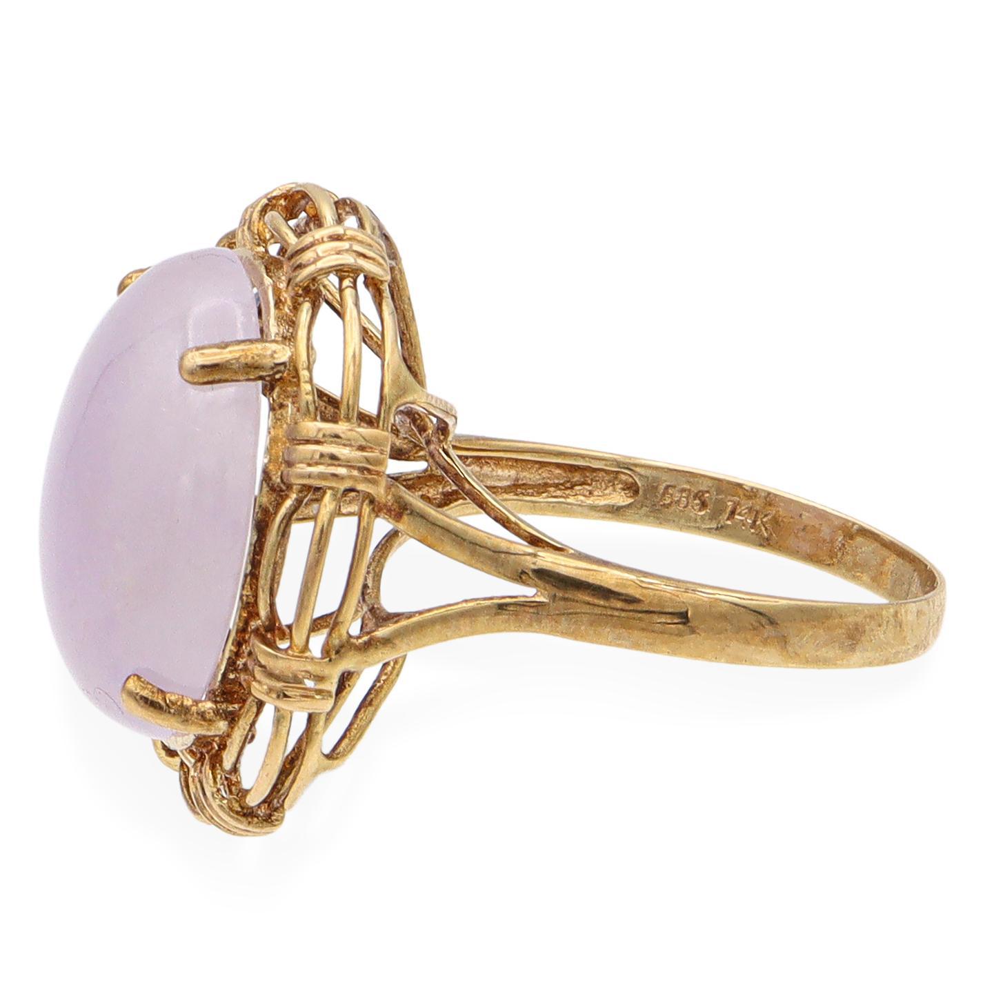 This striking cocktail ring features a captivating purple jade stone, set in a meticulously crafted 14k yellow gold frame. The oval jade is securely held by a series of prongs, surrounded by an intricate woven gold design that adds depth and