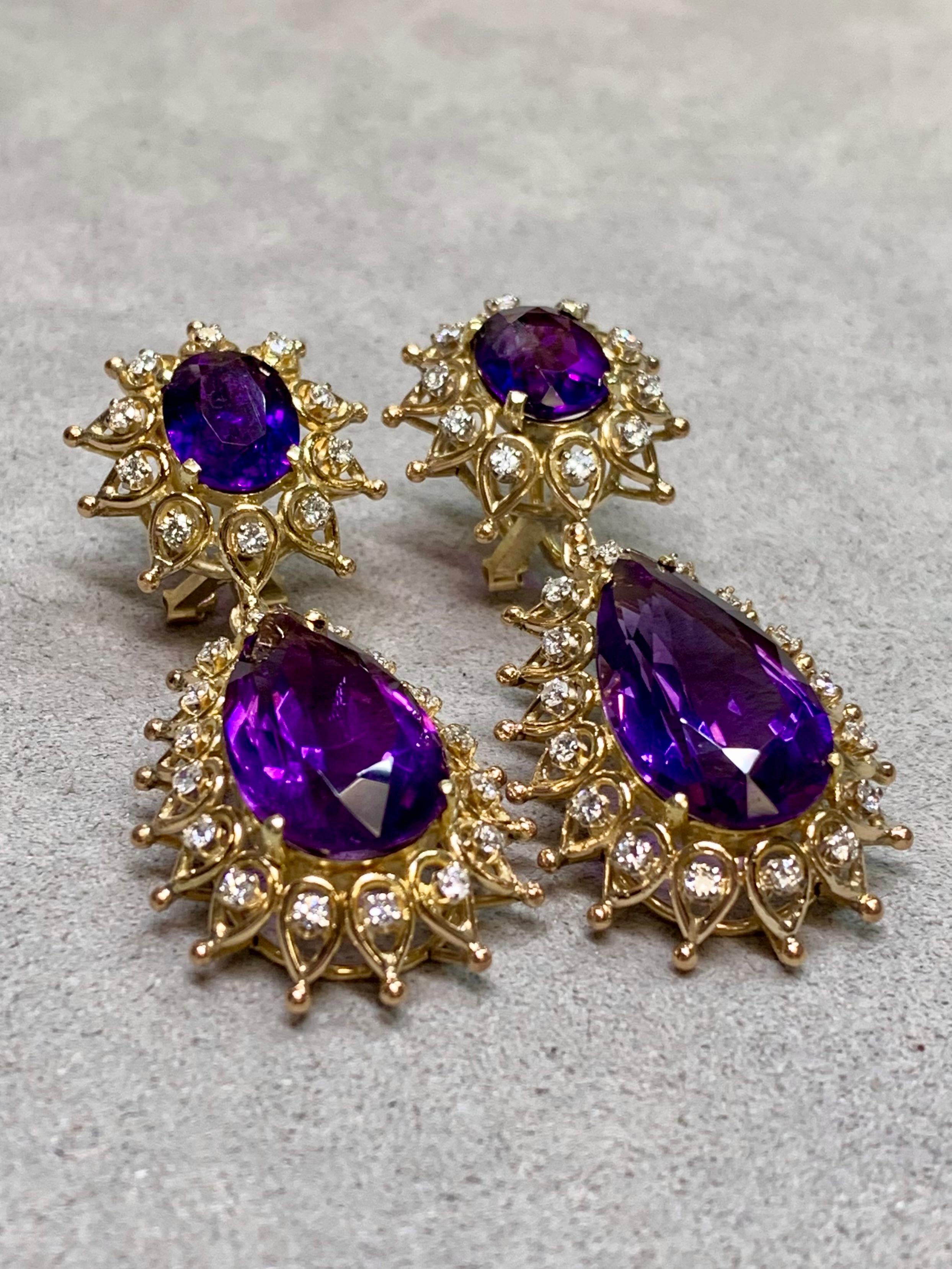 These striking vintage double-drop earrings feature vibrant pear-shaped amethysts and shimmering round diamonds in an elegant, elongated silhouette. The rich purple hue of the amethysts pairs beautifully with the sparkle of the diamonds, creating a
