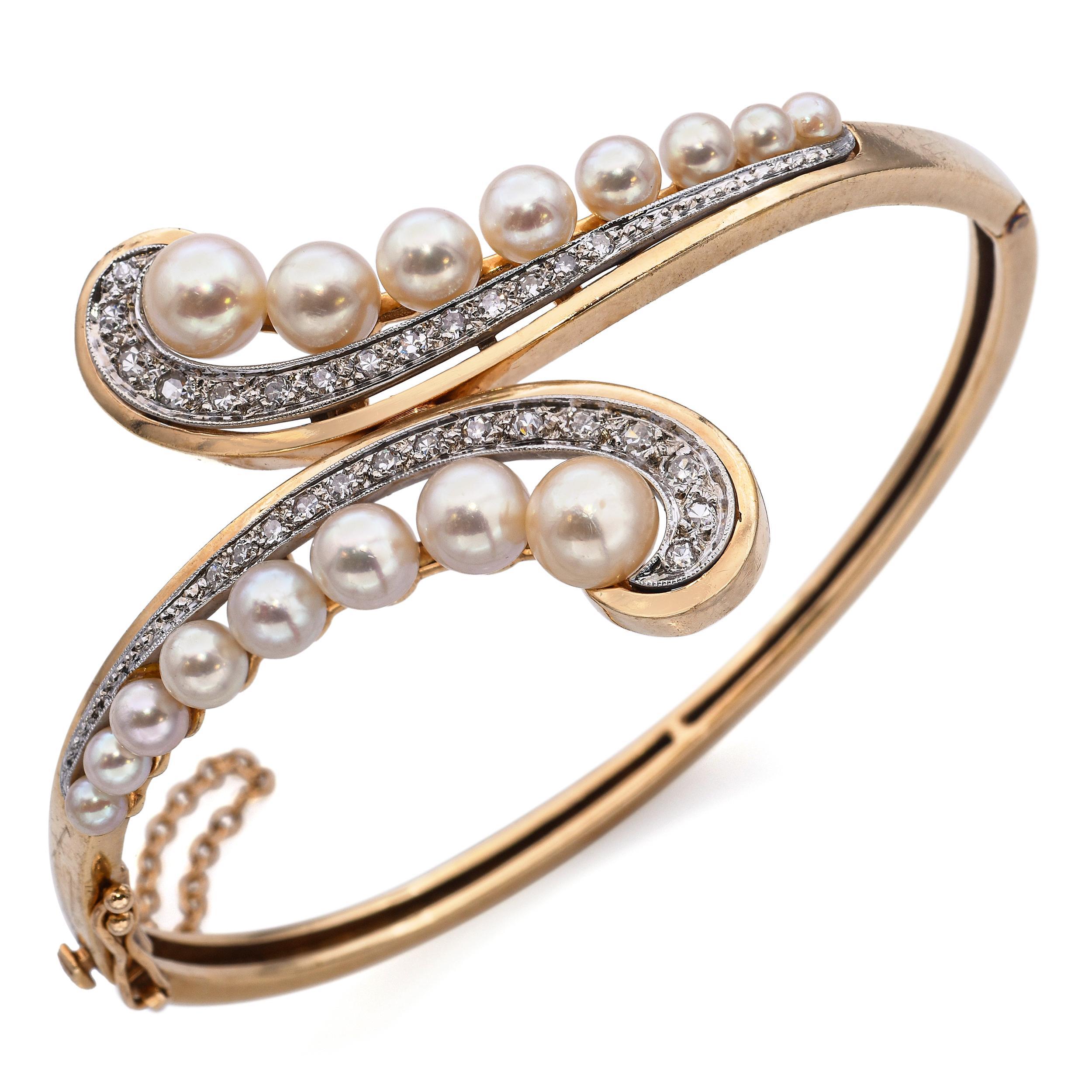 Un bracelet à charnière en or jaune 14k vintage présentant un design élégant où les perles accentuent les rangées de diamants de chaque côté, se graduant graduellement vers le haut. Au centre, une perle lustrée sert de point focal, magnifiquement