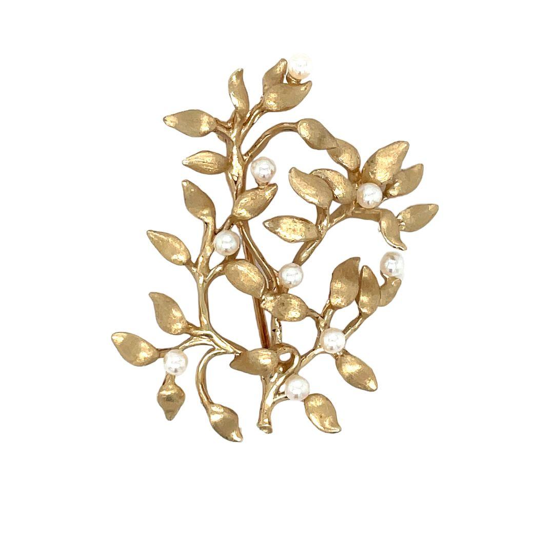 A charming vintage 14K yellow gold brooch. The gold is weaved into a beautiful branch texture with round pearls dripping off the branches, giving it a charming and eye-catching look. The pearls measure 2.7mm and have a nice lustre with hints of