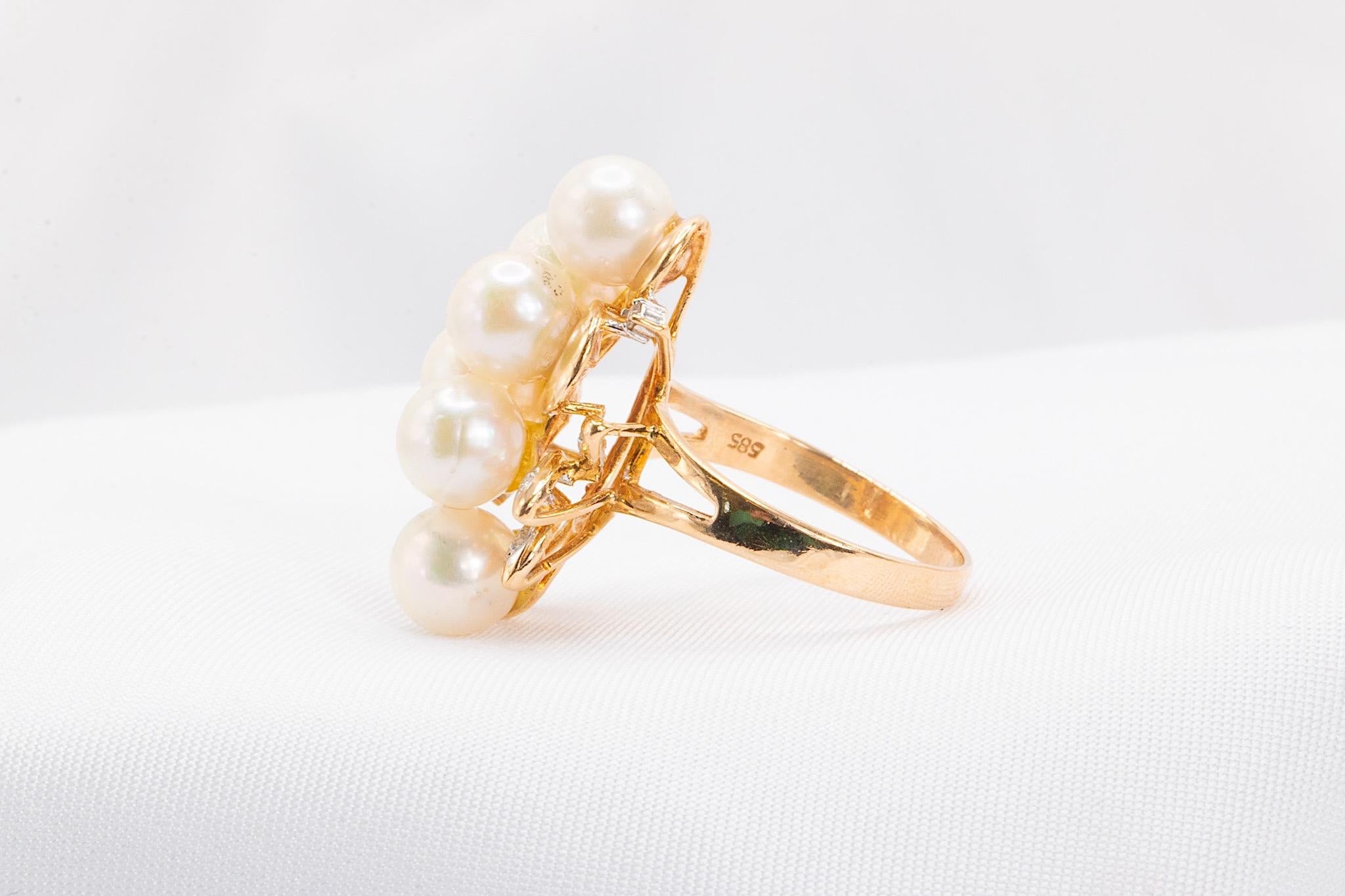 Questo elegante anello in oro giallo 14K degli anni '80 presenta un design unico, con sei perle lucenti e sette piccoli diamanti tondi taglio brillante, per un totale di circa 0,05 carati. Con un peso di 5,8 grammi, questo pezzo di ottima fattura
