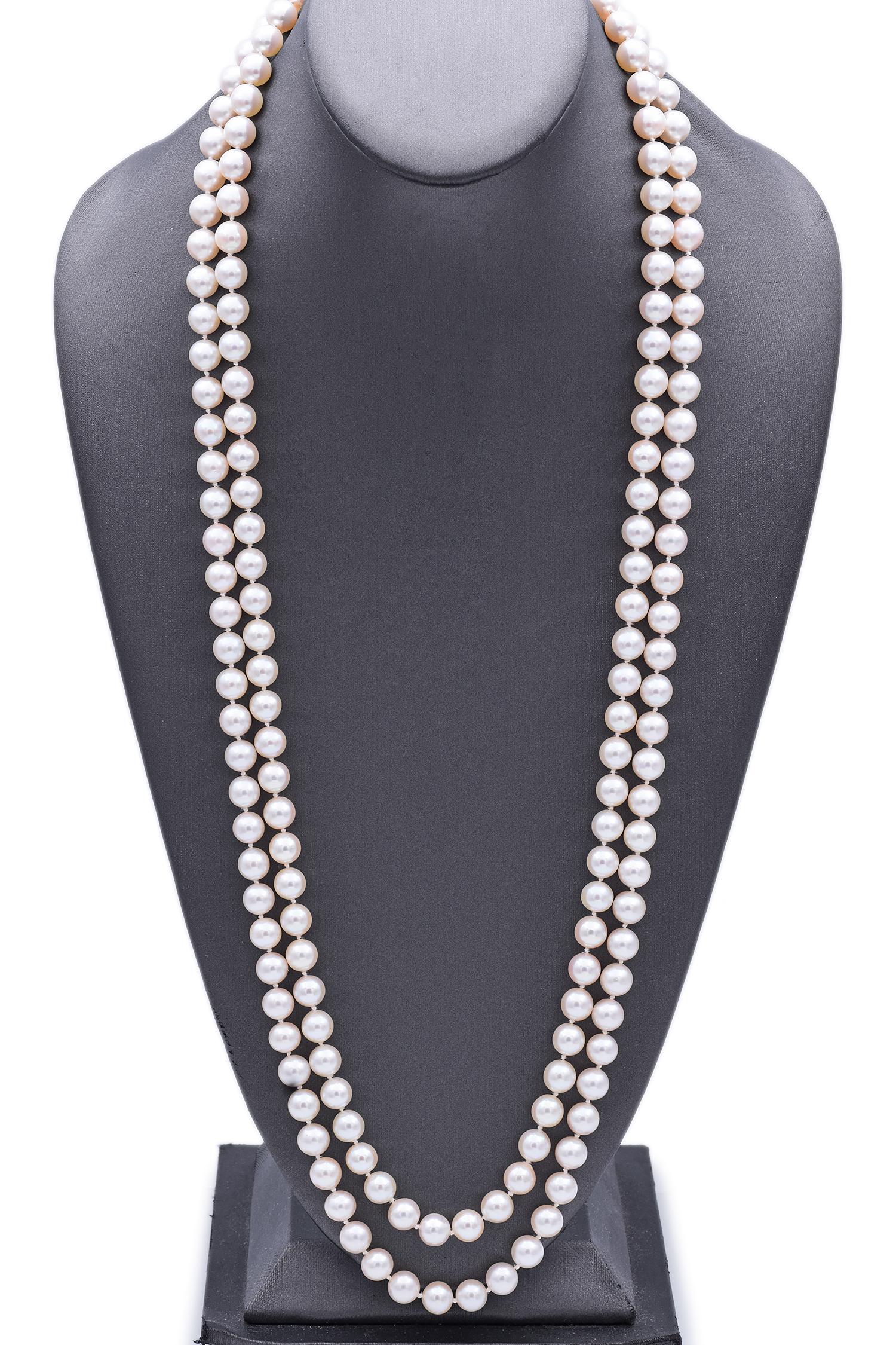 Composed of lustrous white pearls, the necklace is accentuated by a clasp featuring vibrant opals set in 14k gold clasp.
The design showcases a harmonious blend of classic elegance, with a double strand of pearls leading to an ornate opal-adorned