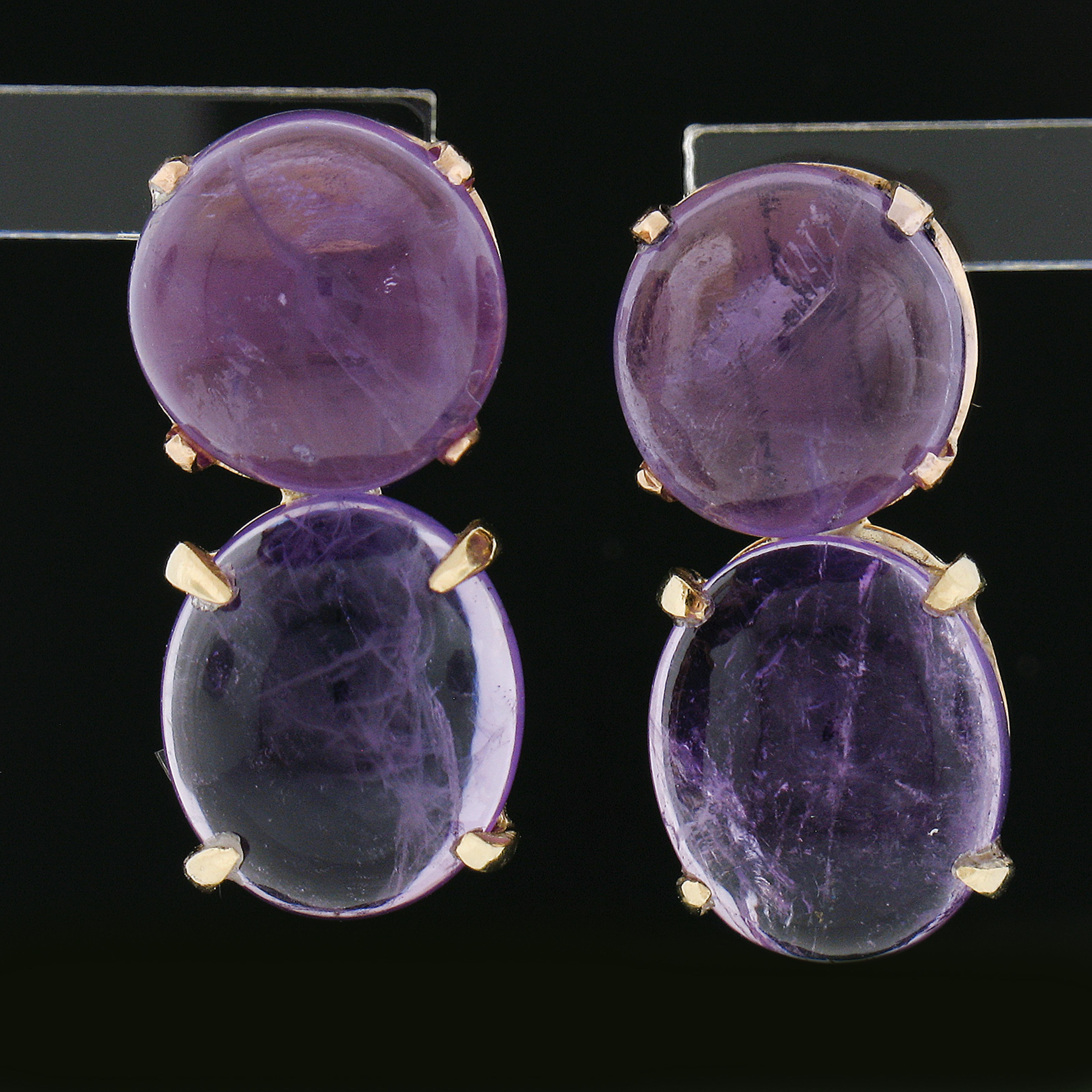 This vintage pair of dangle drop earrings are crafted from solid 14k yellow gold and feature a bold design. The earrings have 2 round cabochon & 2 oval cabochon cut amethyst stones that are neatly prong set. Enjoy!

--Stone(s):--
(2) Natural Genuine