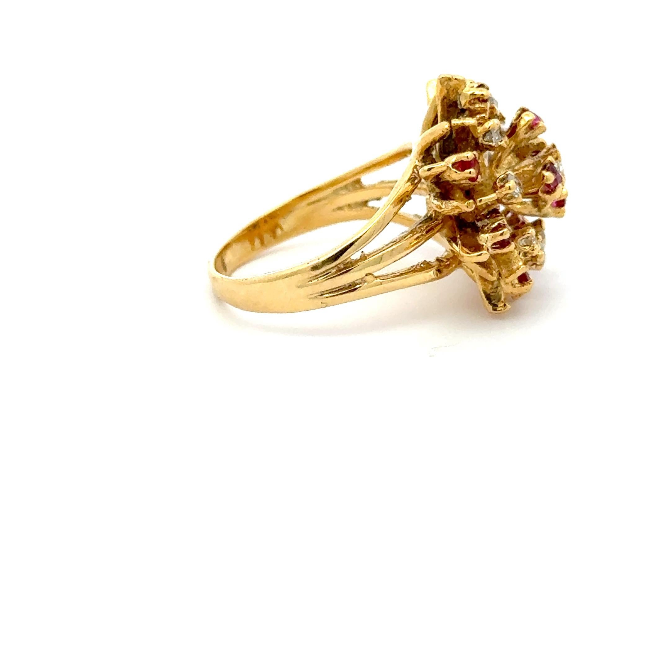 A captivating display of vintage glamour, this bold 14K yellow gold cocktail ring features a dazzling starburst design set with vivid rubies (approx. 0.50 carats) and sparkling round diamonds (approx. 0.25 carats). The multi-dimensional setting