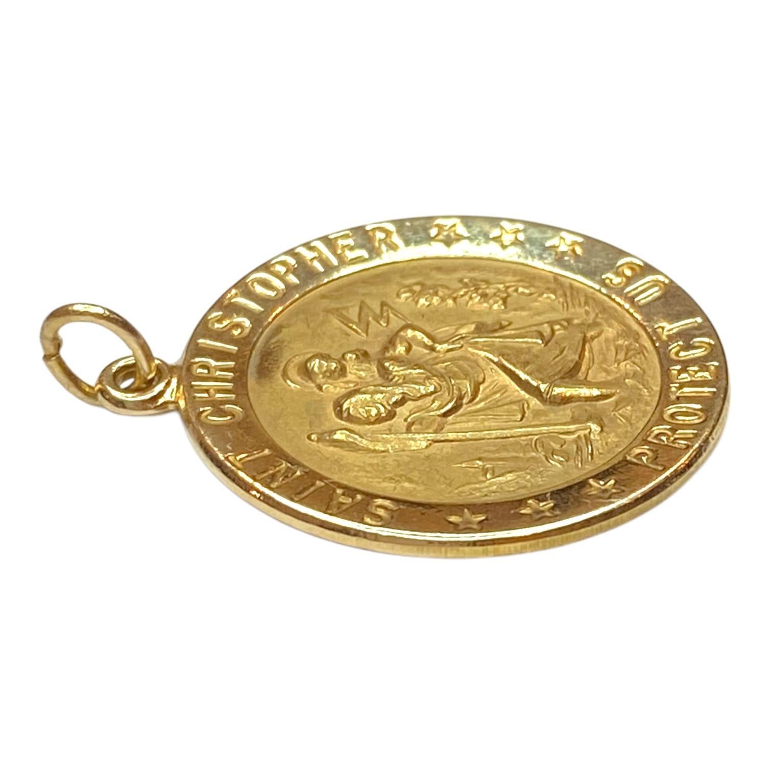 Crafted in 14K yellow gold, the pendant features a detailed depiction of Saint Christopher carrying a child, encircled by the raised message 