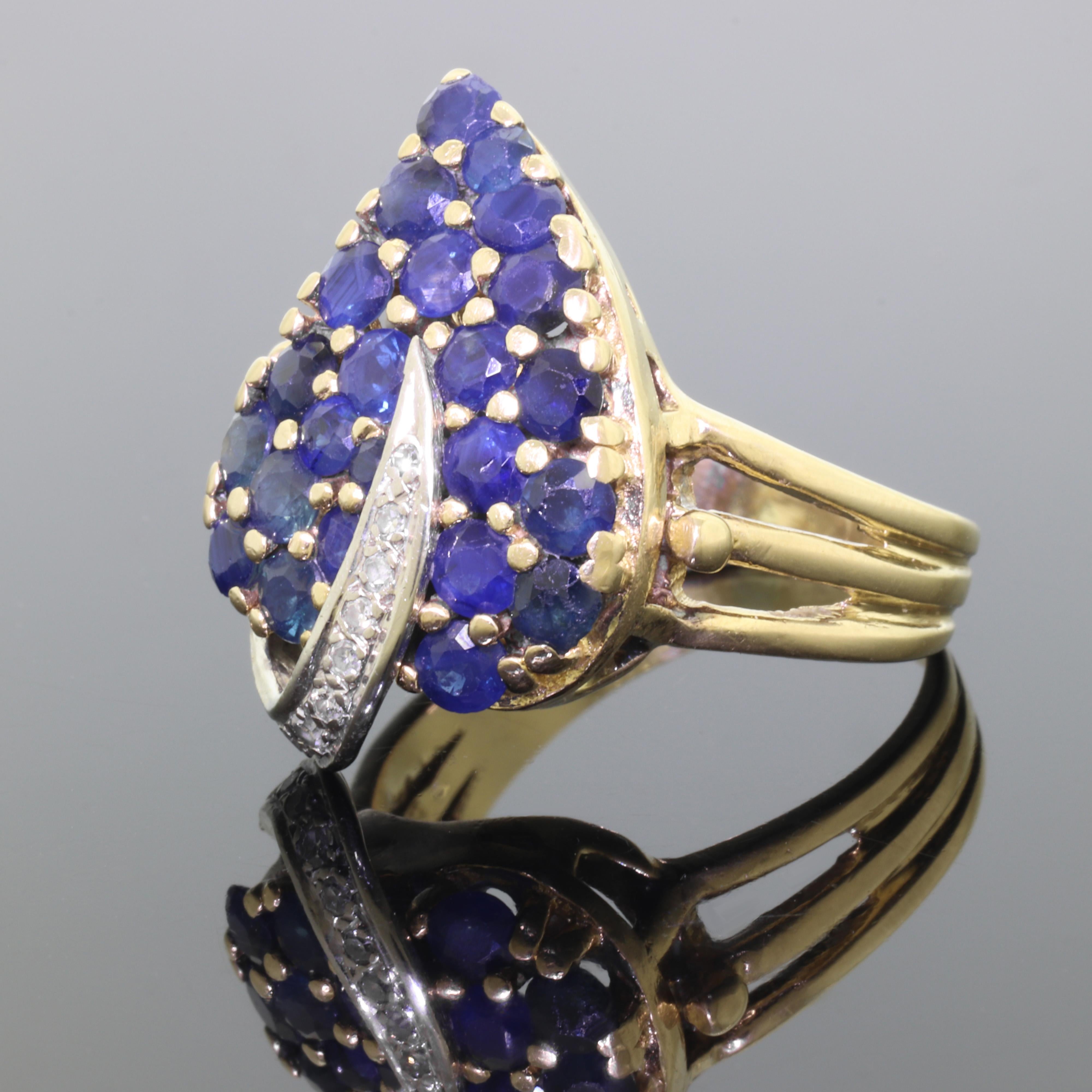 This ring is beautiful and quite unusual in person. A total of 24 perfectly color matched natural Sapphire gemstones are attractively set in an elegant leaf design. The vein / midrib has a nice contrast of white gold and has 8 small diamonds to