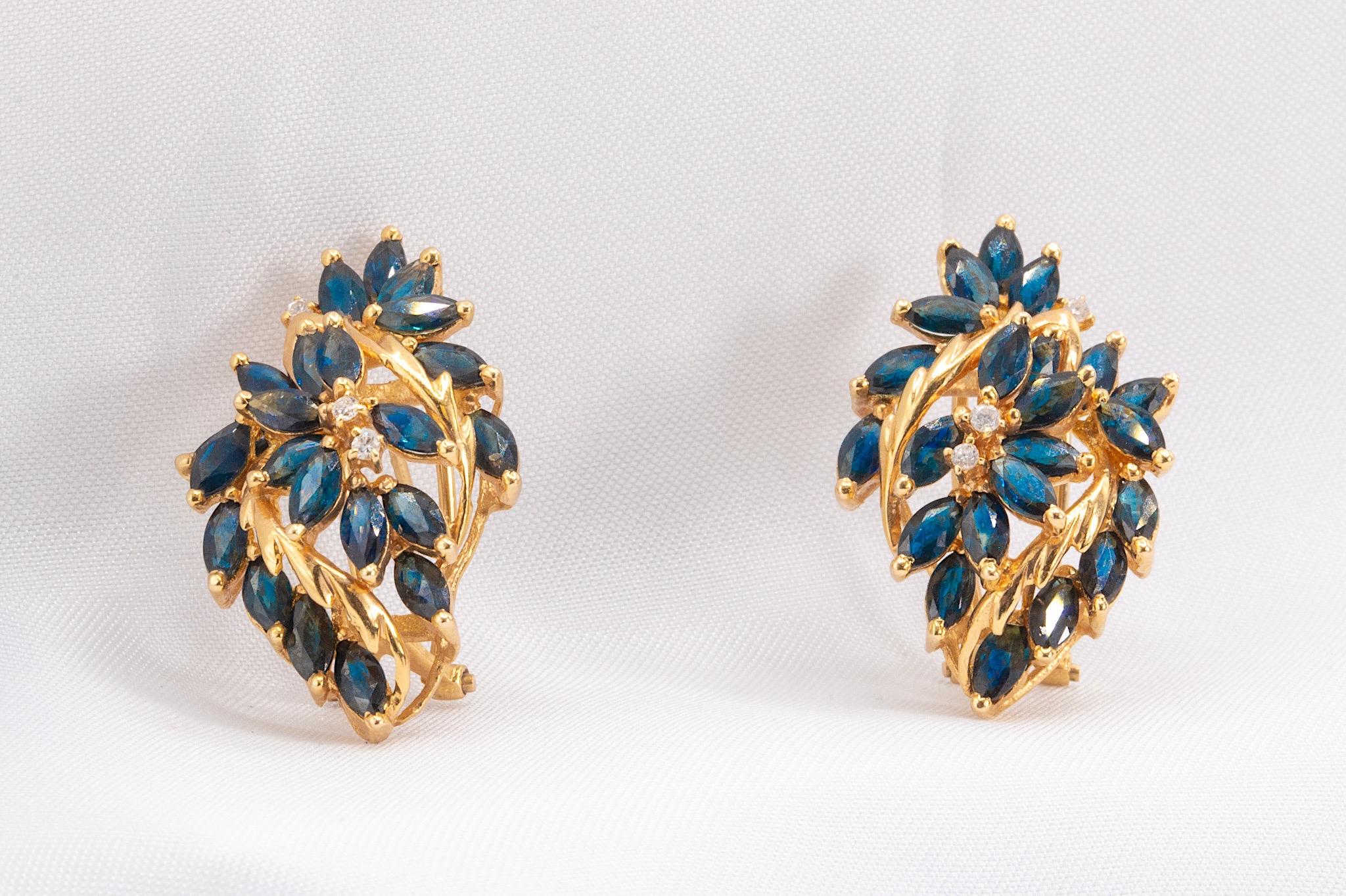 These stunning vintage sapphire and diamond earrings are crafted in 14K yellow gold, showcasing a unique and captivating design. Each earring features 22 vibrant marquise-cut sapphires, totaling approximately 4.5 carats across both earrings, adding