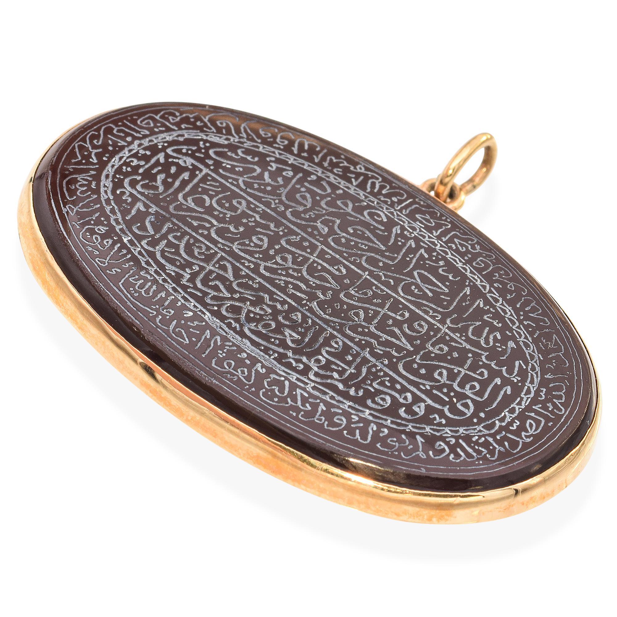 This captivating pendant necklace features an intricately engraved sardonyx stone, set within a sleek yellow gold frame. The detailed script describing protective or spiritual talisman, invoking the wisdom of Prophet Solomon (Sulaiman), who is often