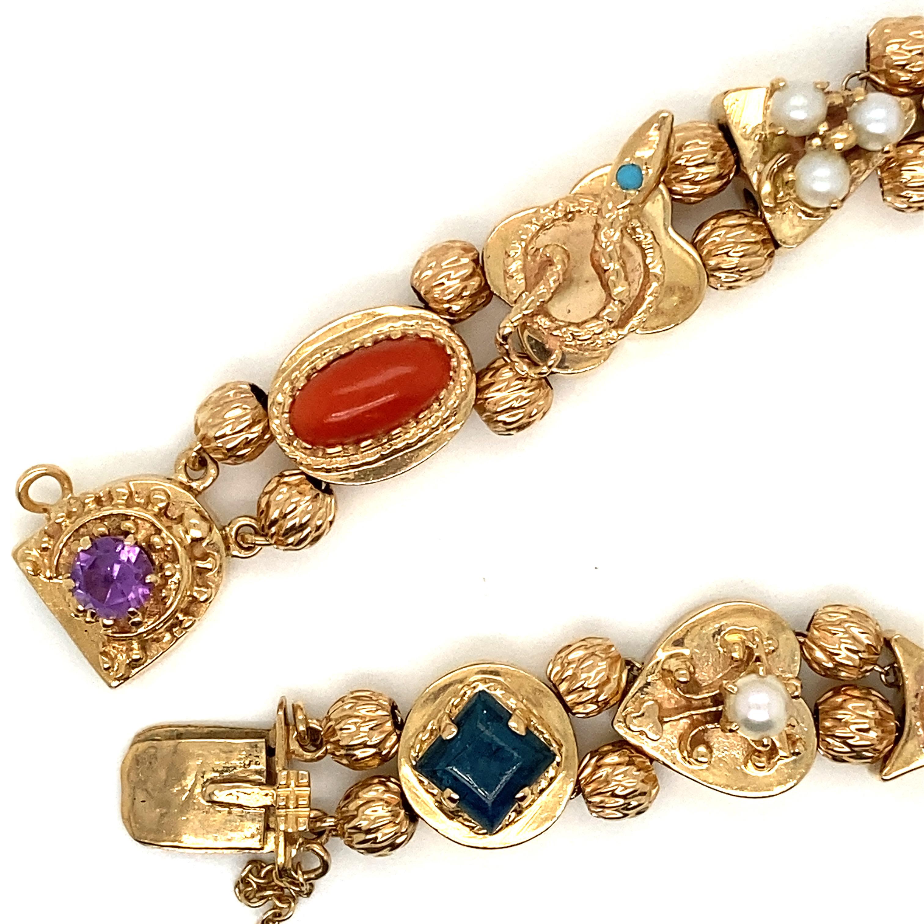 Vintage 14K Yellow Gold Slide Charm Bracelet - Le bracelet contient 10 breloques coulissantes et un fermoir à breloques intégré. Les charmes sont, dans l'ordre, à partir du fermoir : Améthyste, Corail rouge, Serpent d'or avec turquoise, Perles,