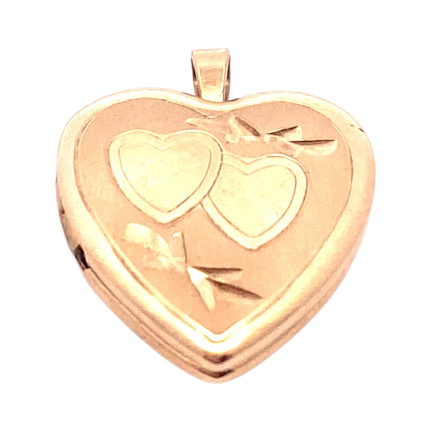 Crafted in 14k yellow gold, this heart-shaped locket features two engraved hearts and delicate bow motifs. Bright polish and satin finish.
Measurements:
Length: 16.0 mm
Width: 13.0 mm
Total Weight: 1.6 g
Marked: 14K PPC (maker's mark)