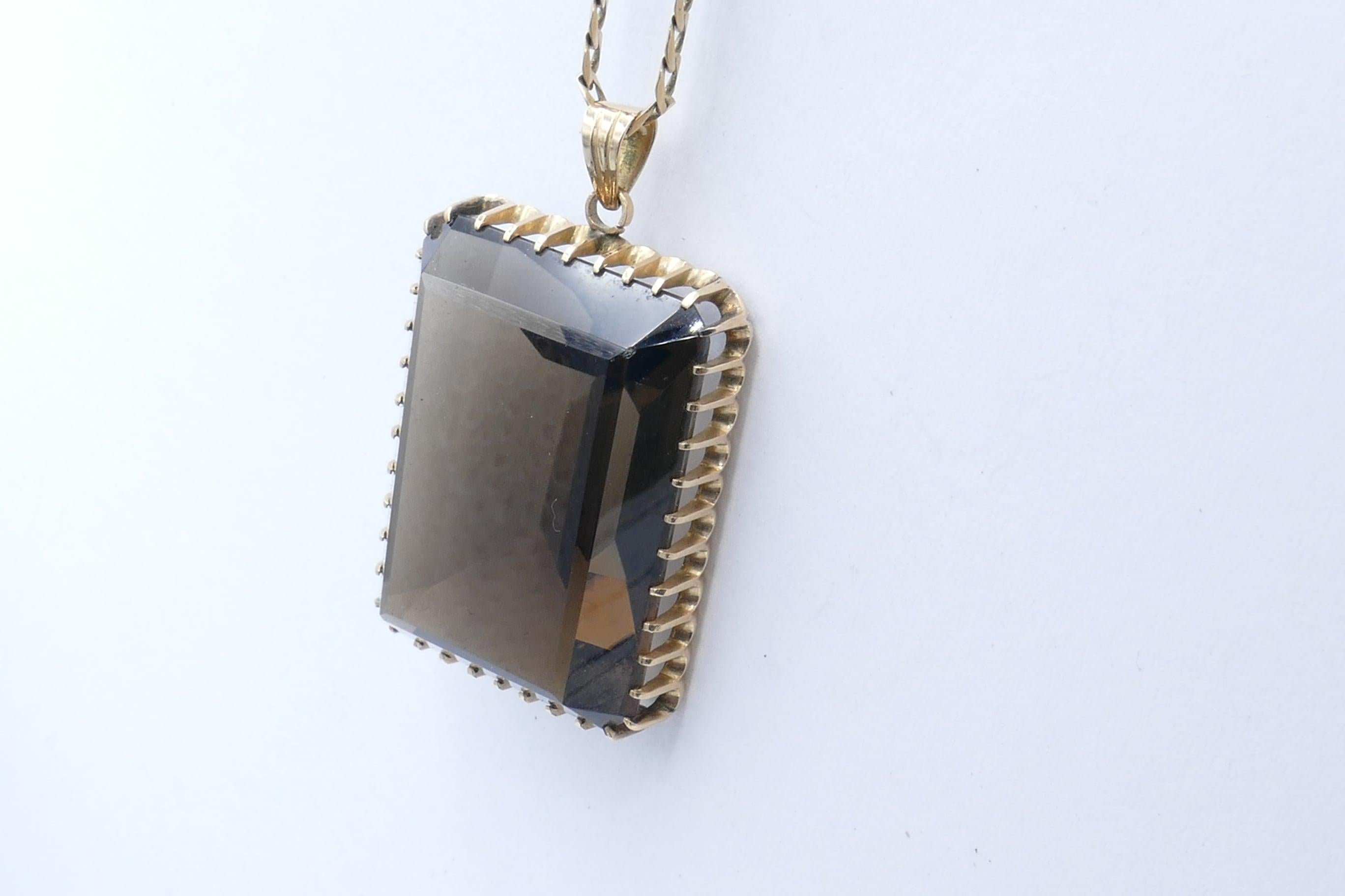This is one VERY large pendant! 30.48 carats! 
Measuring 31.95mm X 23.08mm X 13.76mm, Colour deep yellowish/brown, very eye-clean, rectangular Emerald cut, multi claw set in a decorative Vintage basket mount.
The pendant measures45mm X 25mm