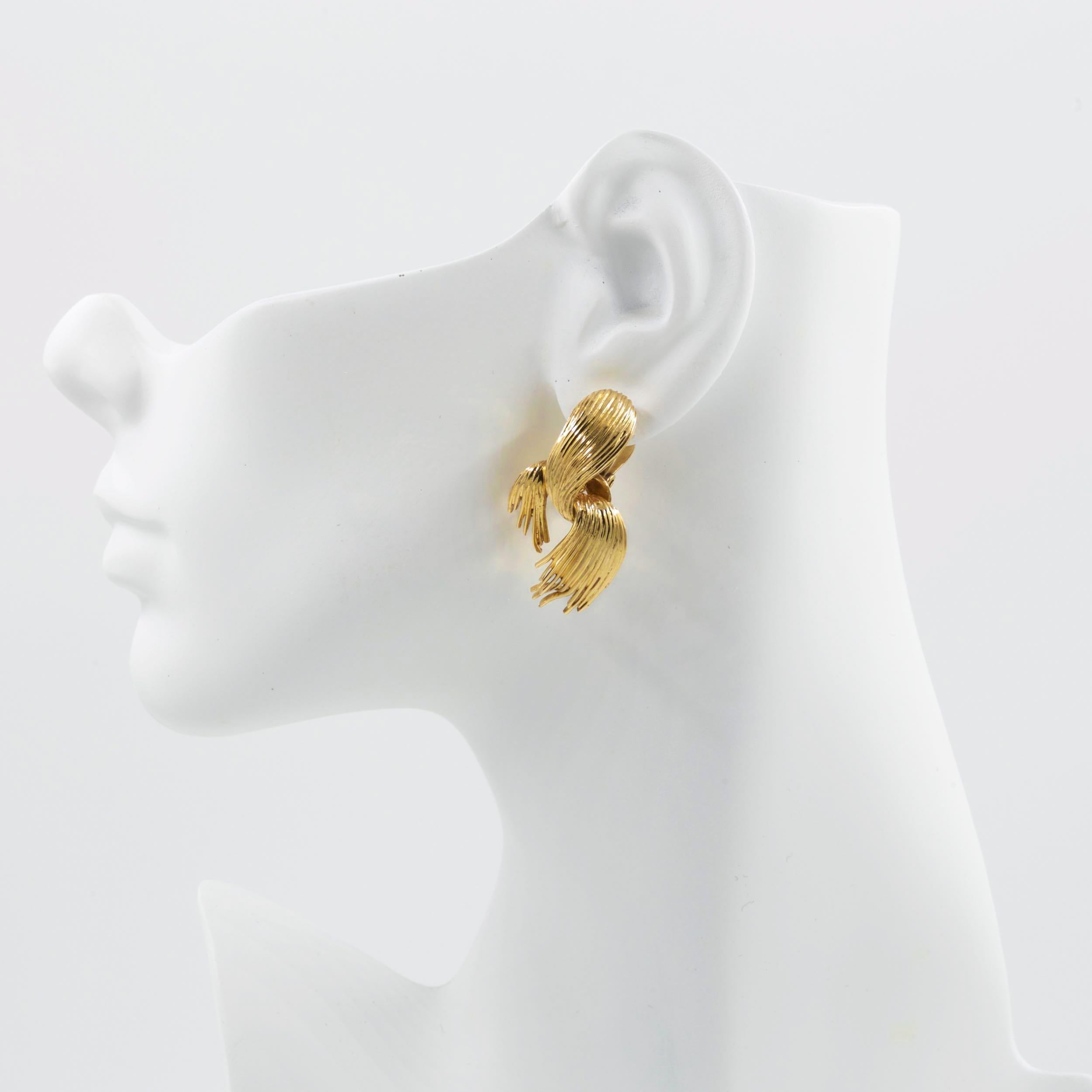 A stylish pair of 14k yellow gold earrings with swirled fronds, they are intricate and beautifully cast in two parts for a swiveling frond. Chaotic and interesting with gorgeous channeled texture, they feature a strong clip-on mechanism.

Item