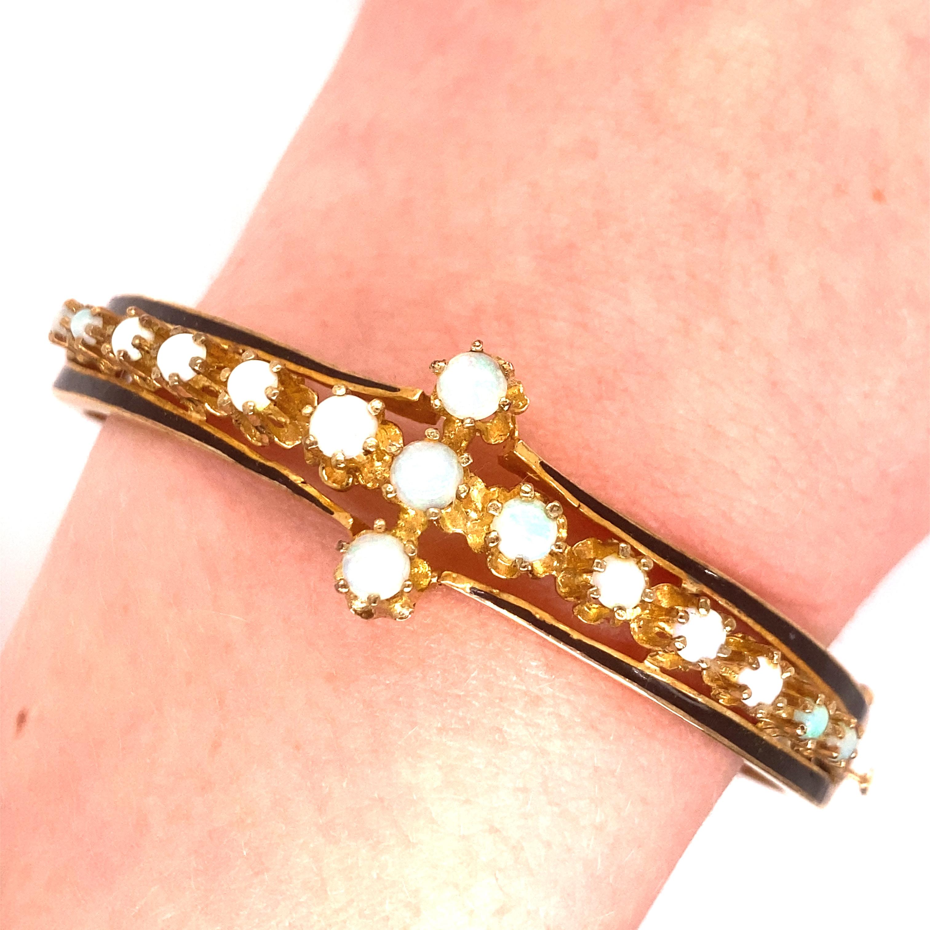 Vintage 14K yellow Gold Victorian Reproduction Opal Bangle - Le bracelet contient 15 opales rondes avec des jeux de couleurs vertes et rouges. L'émail noir se trouve de part et d'autre des opales. La largeur du bracelet est de 0,75 pouce. Le