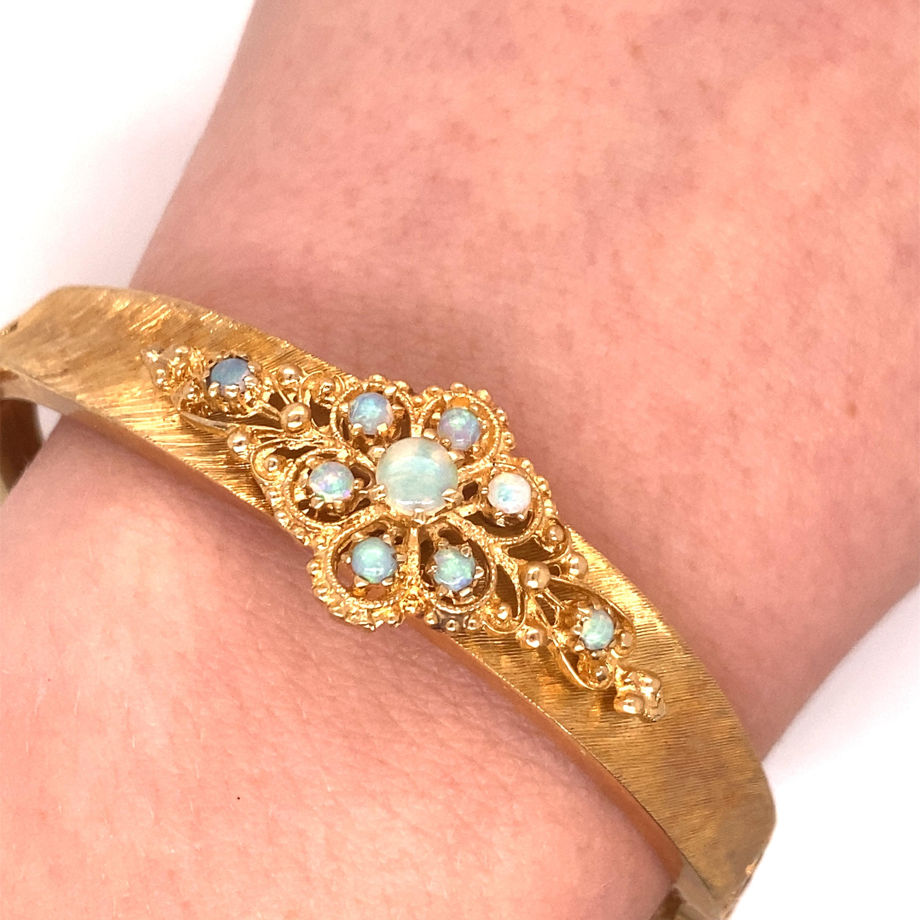 Vintage 14K Yellow Gold Victorian Reproduction Opal Bangle - Le bracelet contient 9 opales rondes avec un jeu de couleur vert/bleu. Le motif en filigrane est monté sur un bracelet en finition Florentine. Le bracelet mesure 0,50 pouce de large. Le
