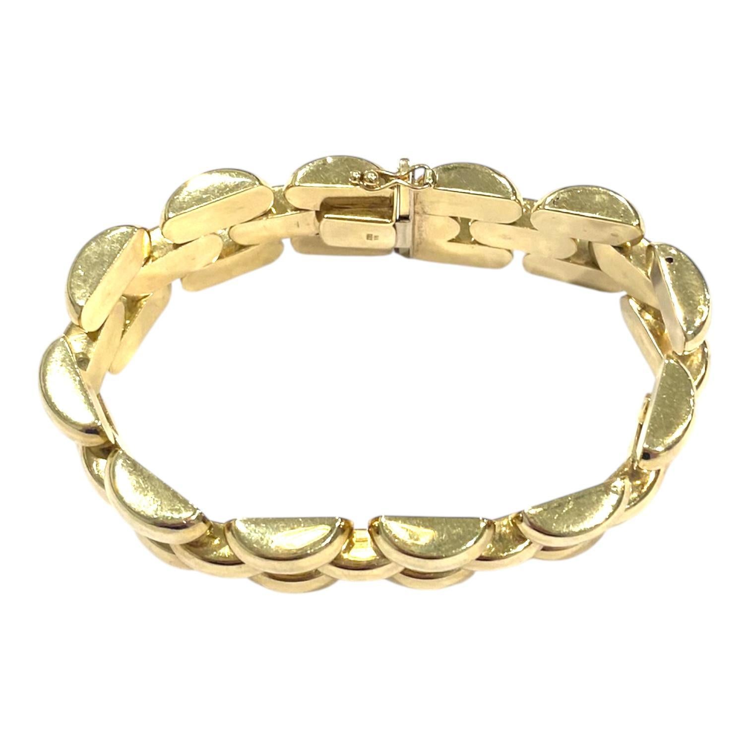 Realizzato in oro giallo 14k, questo braccialetto presenta un design audace a maglie. Le maglie sono lucidate a specchio, creando una superficie liscia e riflettente. Ogni maglia è leggermente arrotondata, aggiungendo dimensione e consistenza al