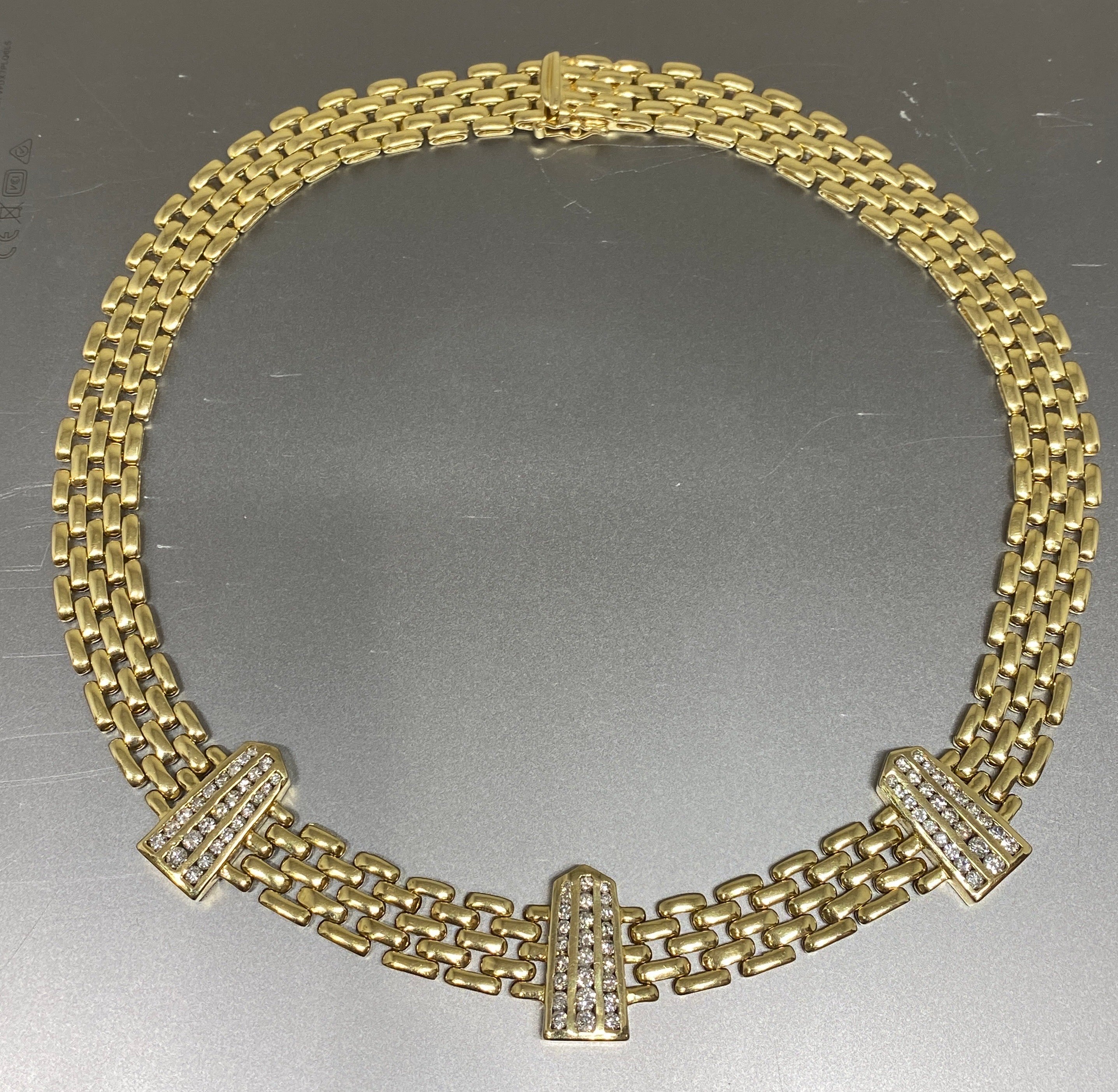 Truly a statement piece, this solid 14K yellow gold necklace will turn heads on any occasion.  This substantial necklace featured a wide woven panther link stationed with three bars set with rows of sparkling round brilliant cut diamonds.  It is