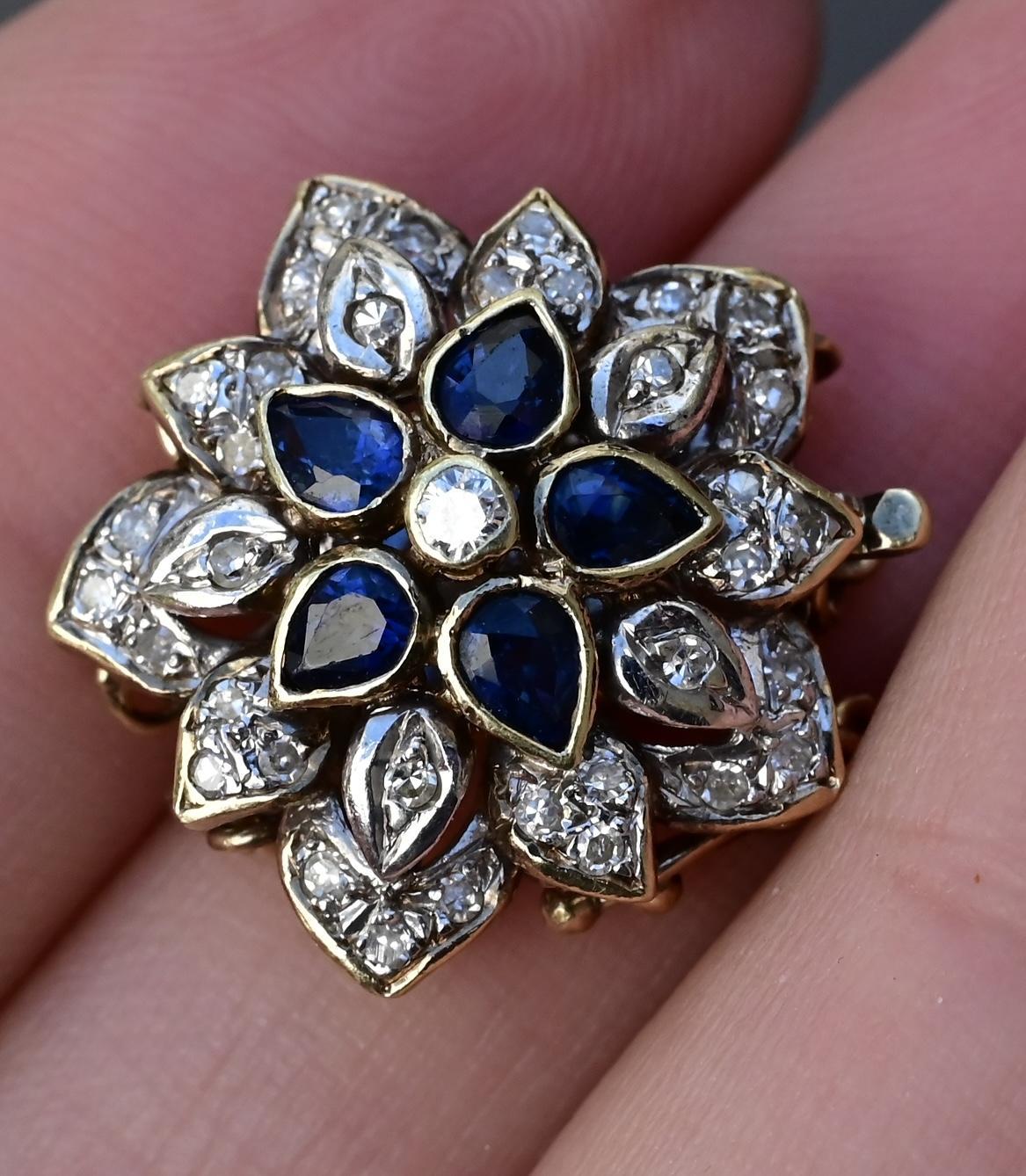 This 14K Yellow and White Gold Floral Bracelet Clasp that can be used as a pendant is an elegant and vintage-inspired piece, featuring blue sapphires and diamond accents in a striking floral motif. The clasp/pendant weighs 5.15 grams and is marked
