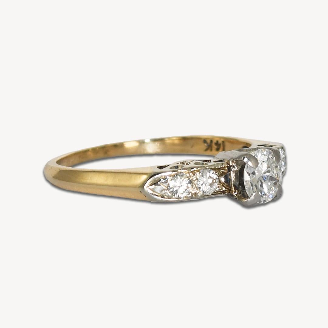 This beautiful, solitaire with accents style 14 karat yellow and white gold ring weighs 2.6 grams.
It contains a solitaire round brilliant diamond, with a carat weight of 0.40, VS2-SI1 clarity, and H-I-J color, and is accented by small diamonds on