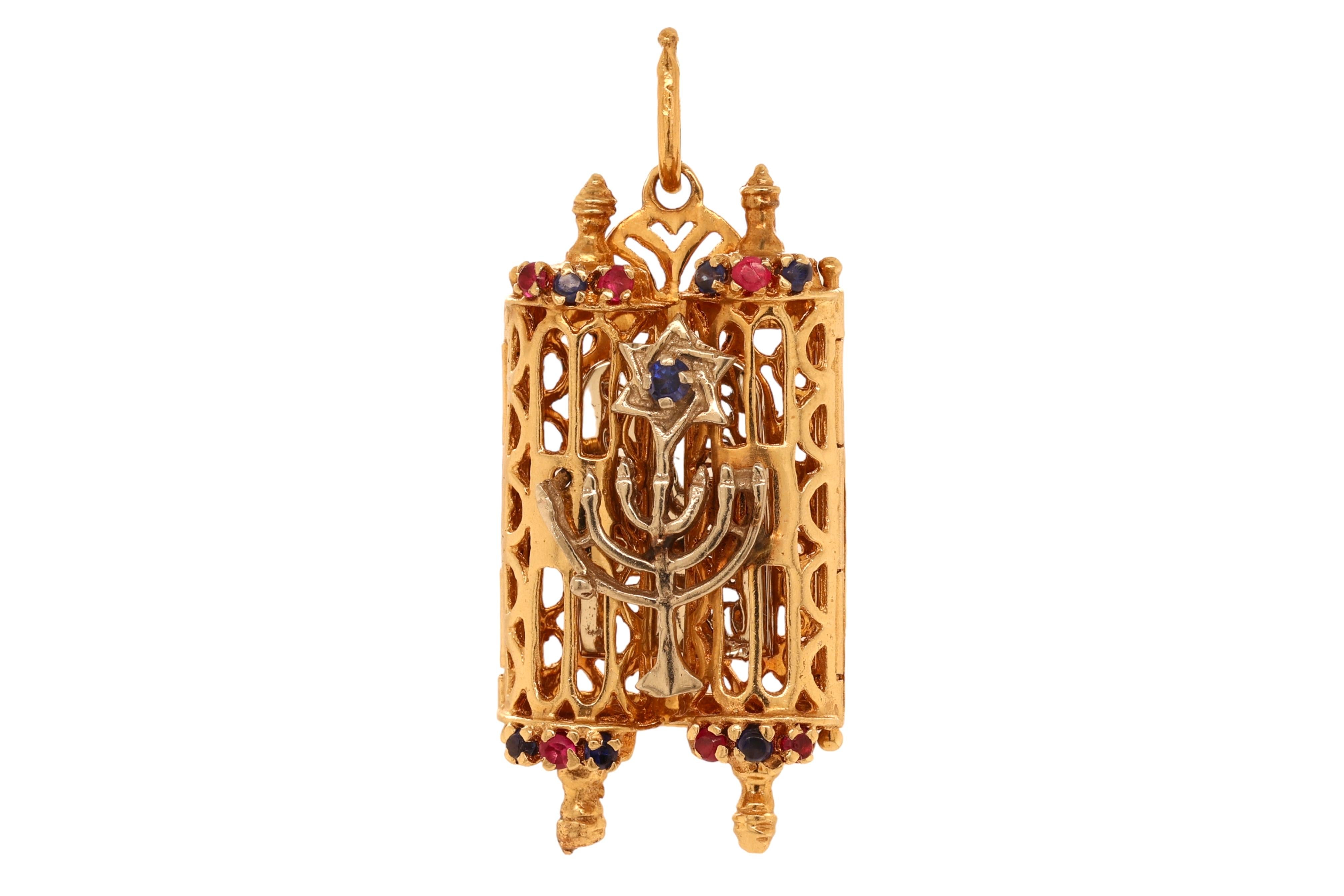 Vintage 14 kt. Gold Judaica Torah Scroll Pendant Holder With Menorah and Star of David, 10 Commandments

Sapphire: 7 little round sapphires

Ruby: 6 little round rubies

Material: 14kt yellow gold

Measurements: 44.8 mm x 19.7 mm x 7.1 mm

Total