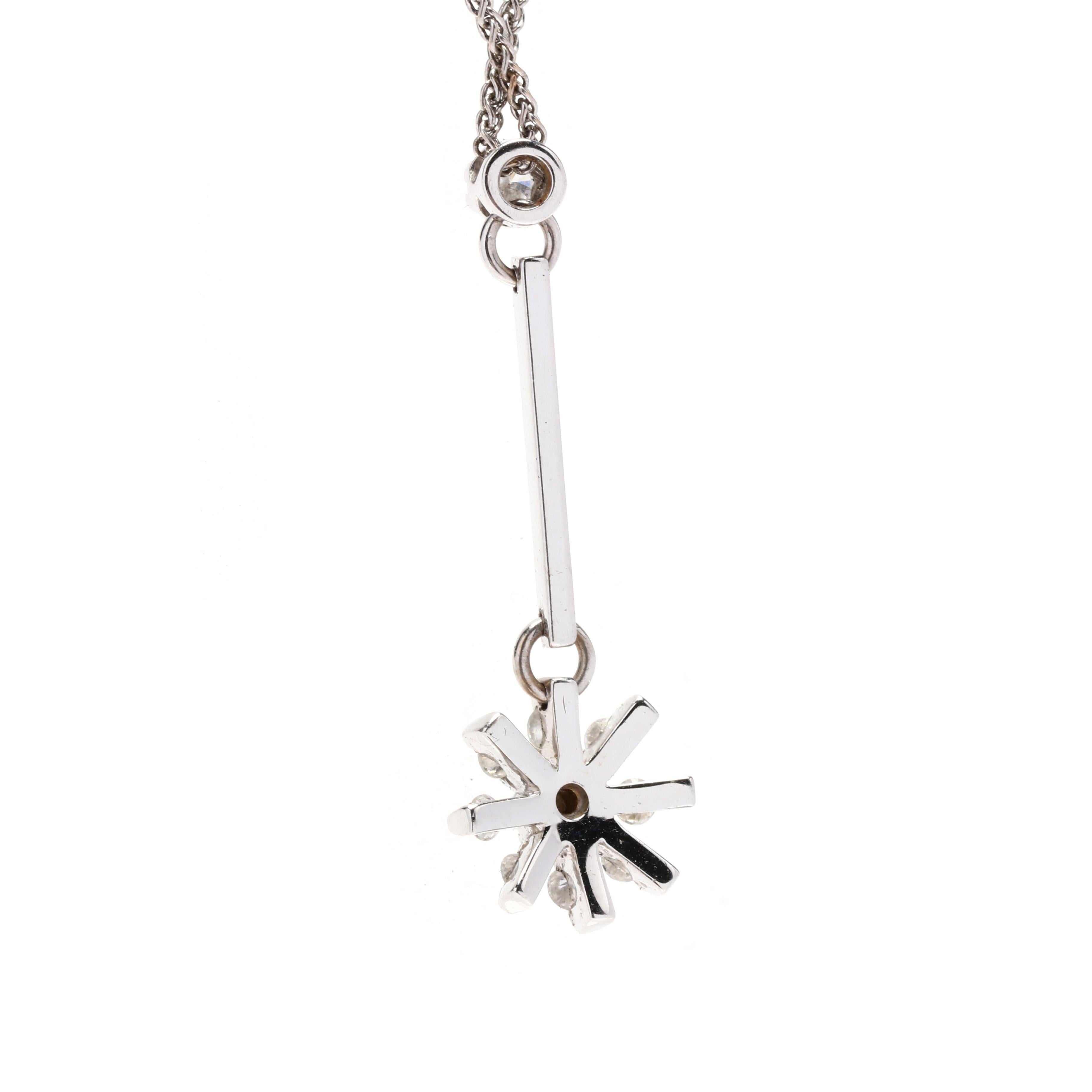 A vintage 14 karat white gold diamond flower necklace, This lariat style necklace features a thin bar drop suspending a simple flower motif set with round brilliant cut diamonds weighing approximately .22 total carats and with a thin wheat chain and