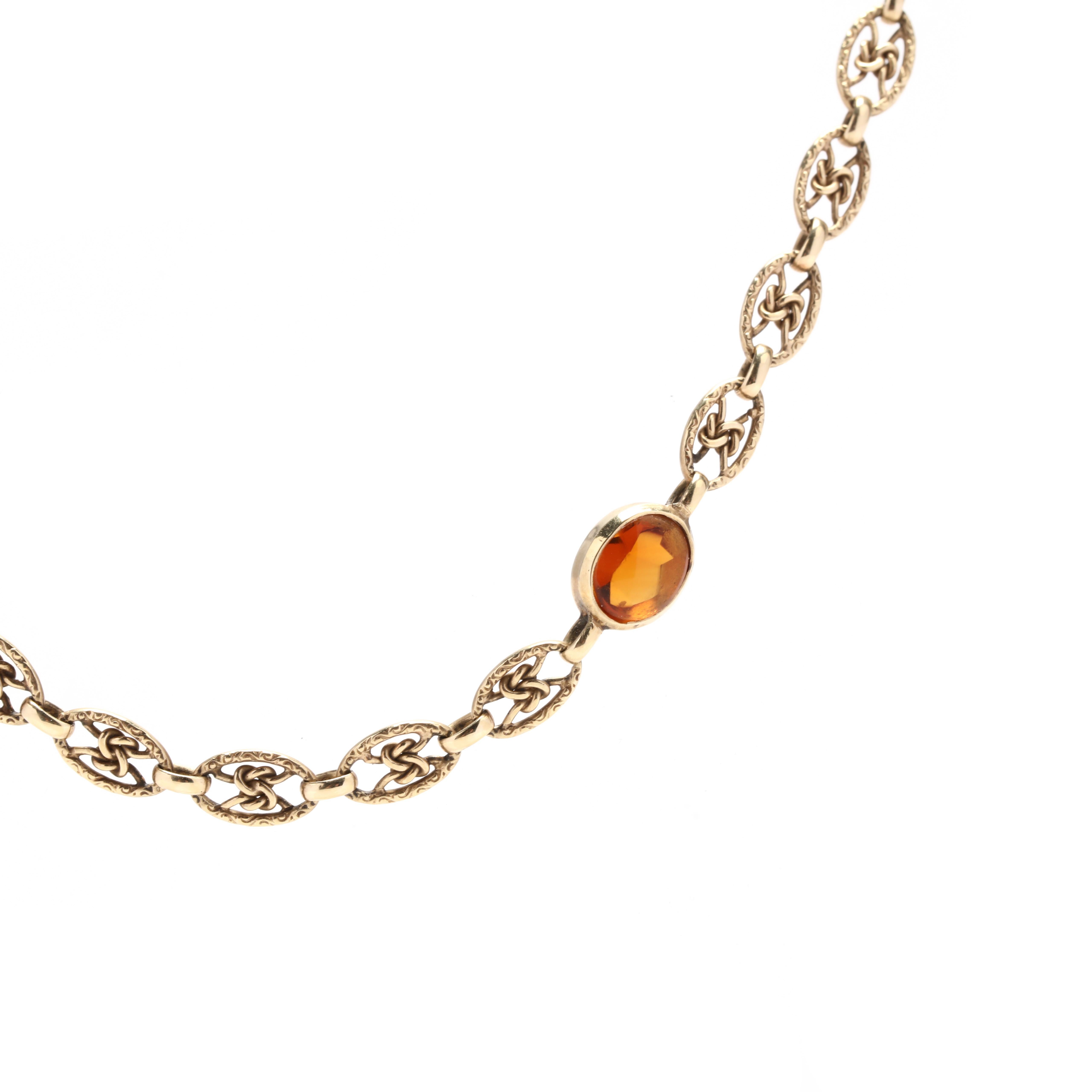 A vintage 14 karat yellow gold citrine knot chain necklace. This necklace features an oval link design with knot motifs in the center and with seven oval cut bezel set madeira citrine stations throughout.

Stones:
- citrine, 7 stones
- oval cut
-