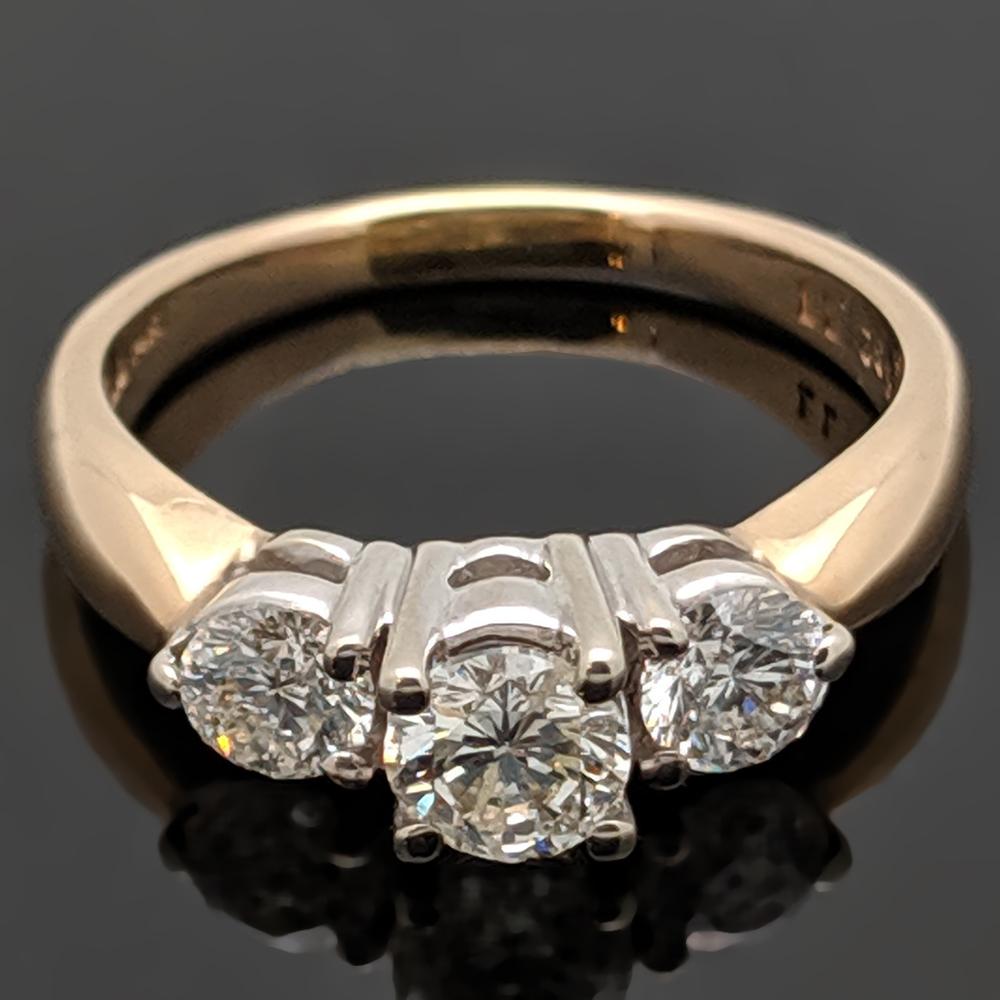 A vintage three-stone 14kt yellow gold ring featuring a center round brilliant cut diamond with an estimated weight of 0.31ct and side diamonds at an estimated 0.50 cttw. Estimated weight of gold is 2 gr. 

We will size it for you.



