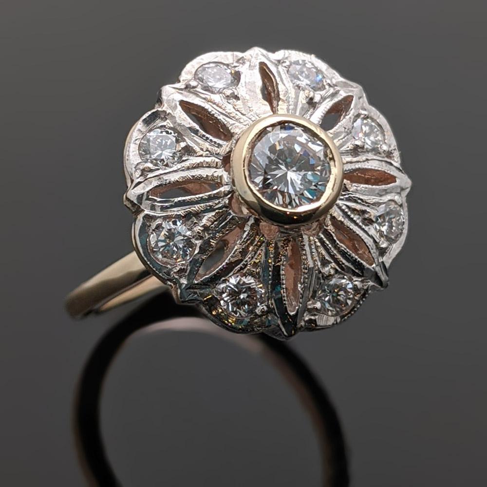 Unique Edwardian ring with an elevated round brilliant cut center diamond with an estimated weight 0.33 ct. and surrounding diamonds with an estimated weight of 0.45 cttw. Estimated weight of gold 4.5 gr. 

We will size it for you.

