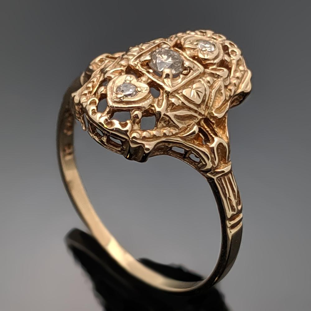 This is a low-profile, vintage 14kt yellow gold and diamonds Edwardian ring. The center diamond is a round brilliant cut diamond with an estimated weight 0.07ct. with upper and lower diamonds at 0.02 cttw. Estimated weight of gold 2 gr. 

We will