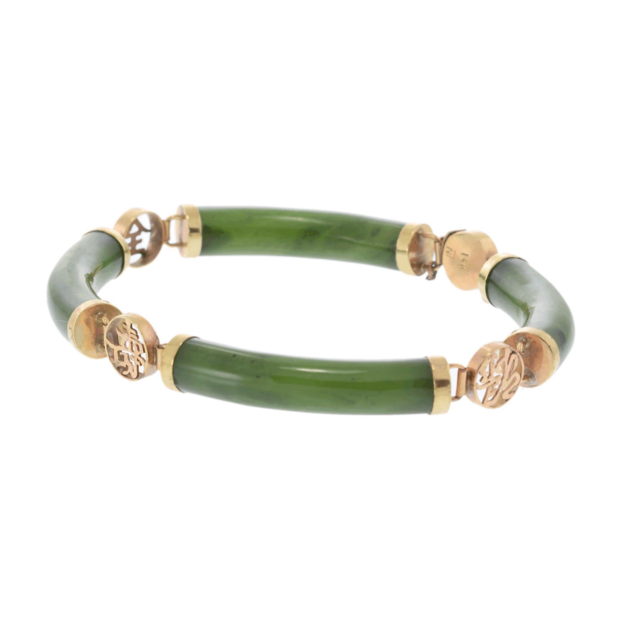 A refined link bracelet featuring smooth jade segments.

The jade displays a rich green hue, elegantly complemented by 14k yellow gold accents.

A central gold medallion with intricate detailing adds a touch of sophistication.

This exquisite piece