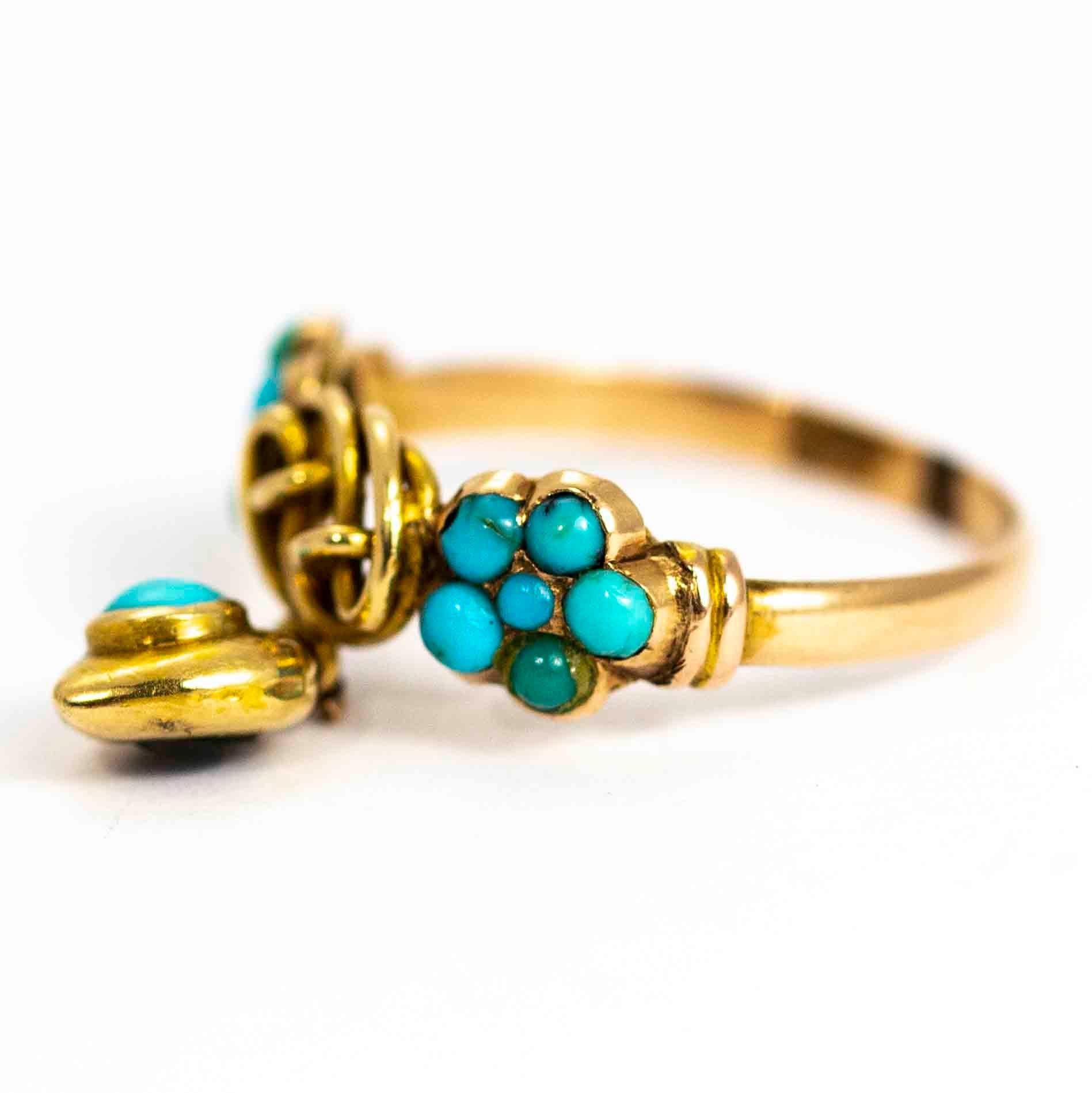 A spectacular vintage ring. The band is set with a pair of beautiful turquoise cabochon clusters flanking stunning gold lover's knot. Hanging from this is a exquisite heart pendant set with a large turquoise cabochon. The heart has a glazed locket