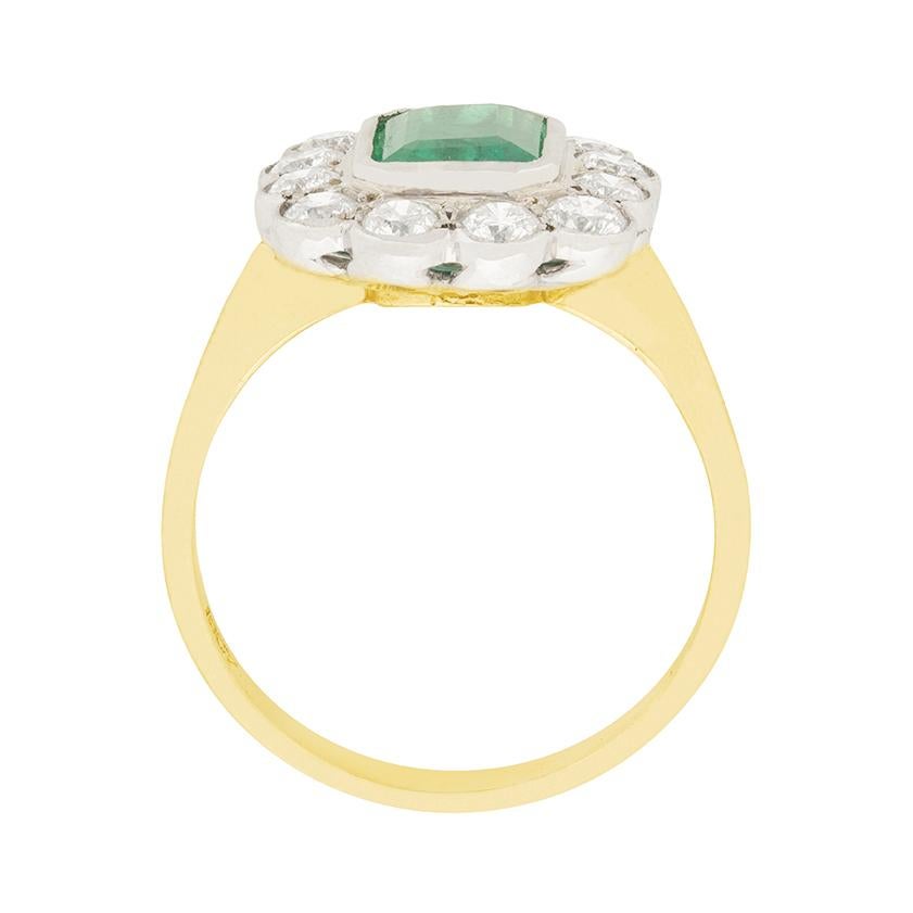 A vibrant 1.50 carat emerald is the focus of this beautiful vintage ring. It is emerald cut, and has a rich green colour. Surrounding the emerald are 1.80 carat of round brilliant cut diamonds. They are F colour and VS clarity. The gems are all rub