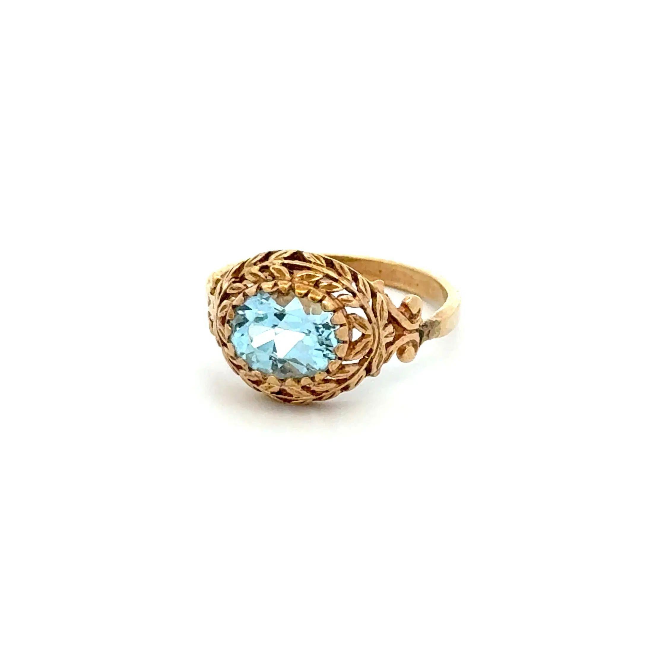 Simply Beautiful! Finely detailed Blue Topaz Vintage Gold Solitaire Cocktail Ring. Securely nestled and Hand Bezel set with a 1.5 Carat Oval Blue Topaz. Beautifully Hand crafted in 14K Yellow Gold Filigree, 20 Prong Wreath design. Ring size 9, we