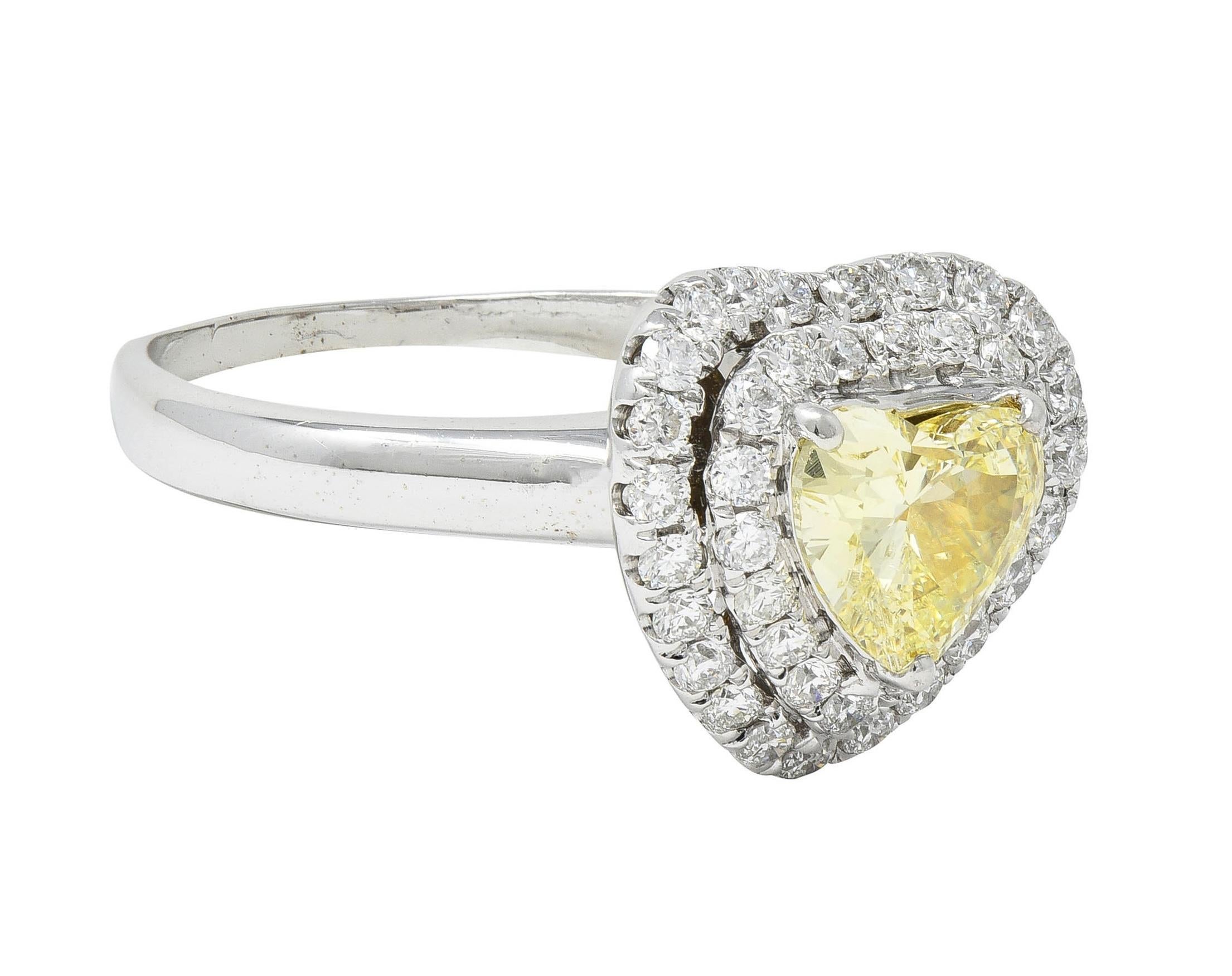 Centering a heart cut diamond weighing 0.90 carat total - natural fancy light yellow with SI2 clarity
Prong set in yellow gold with a contoured double halo surround of round brilliant cut diamonds
Weighing approximately 0.60 carat total - G color