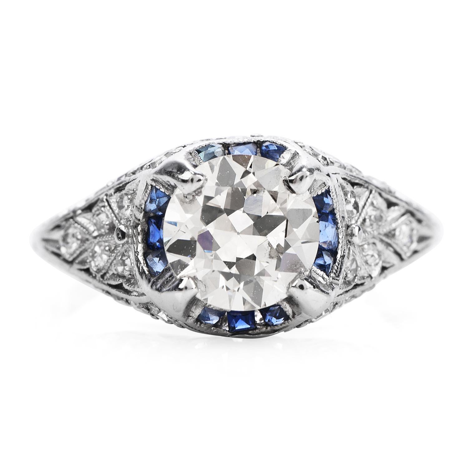 Vintage Diamond & Blue Sapphire engagement ring with engraved accents sides,

Crafted in solid platinum,

The center diamond is a round European-cut, a prong-set genuine diamond weighing in total 1.50 carats, (I-J color and SI1 Clarity),

The sides